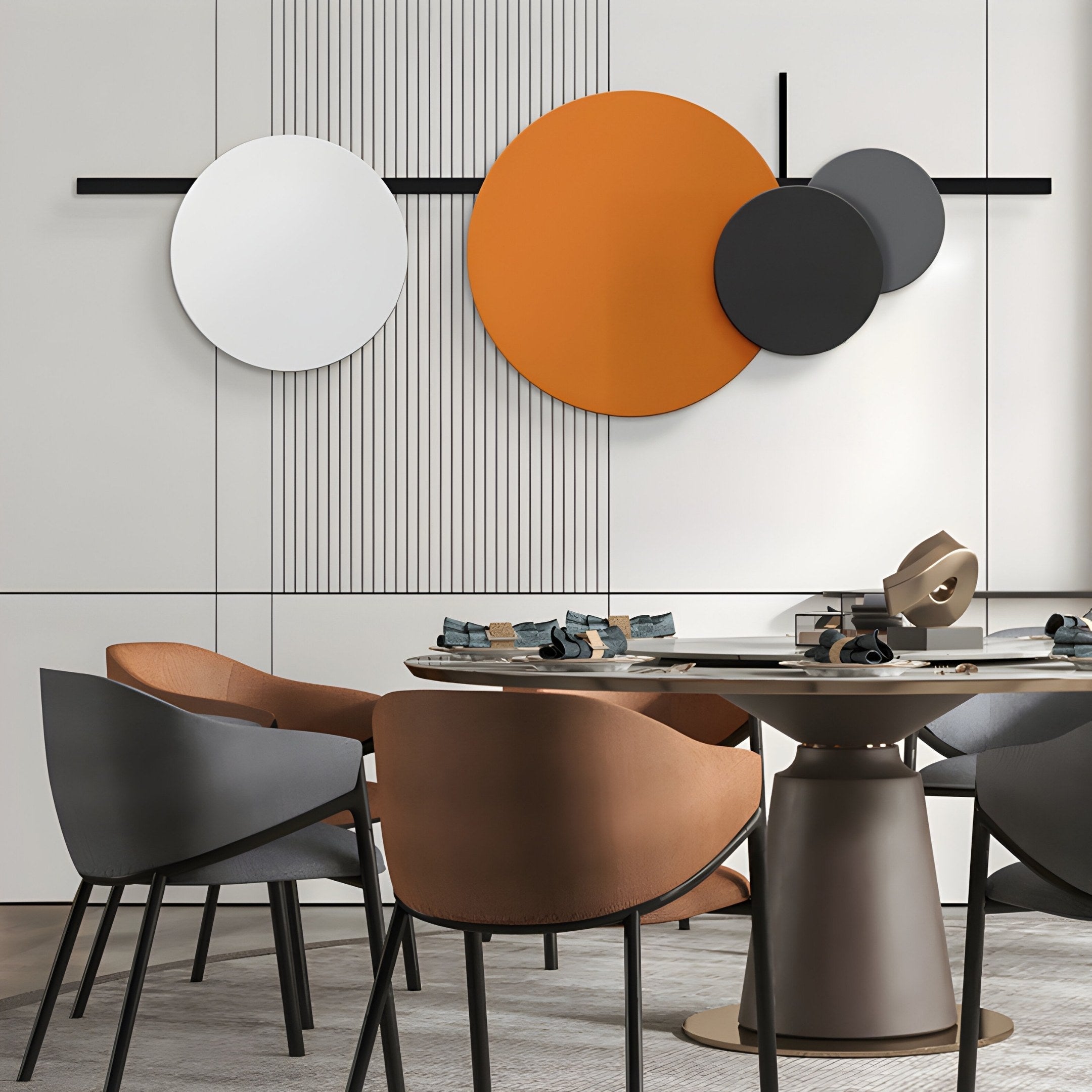 A modern dining room features a circular table with brown and gray chairs. The vibrant wall is adorned with the Orbit II Dynamic Flow Multicoloured Circular Wall Art by Giant Sculptures, showcasing bold geometric patterns in white, orange, dark gray, and light gray. Neutral panels enhance the textured interior.