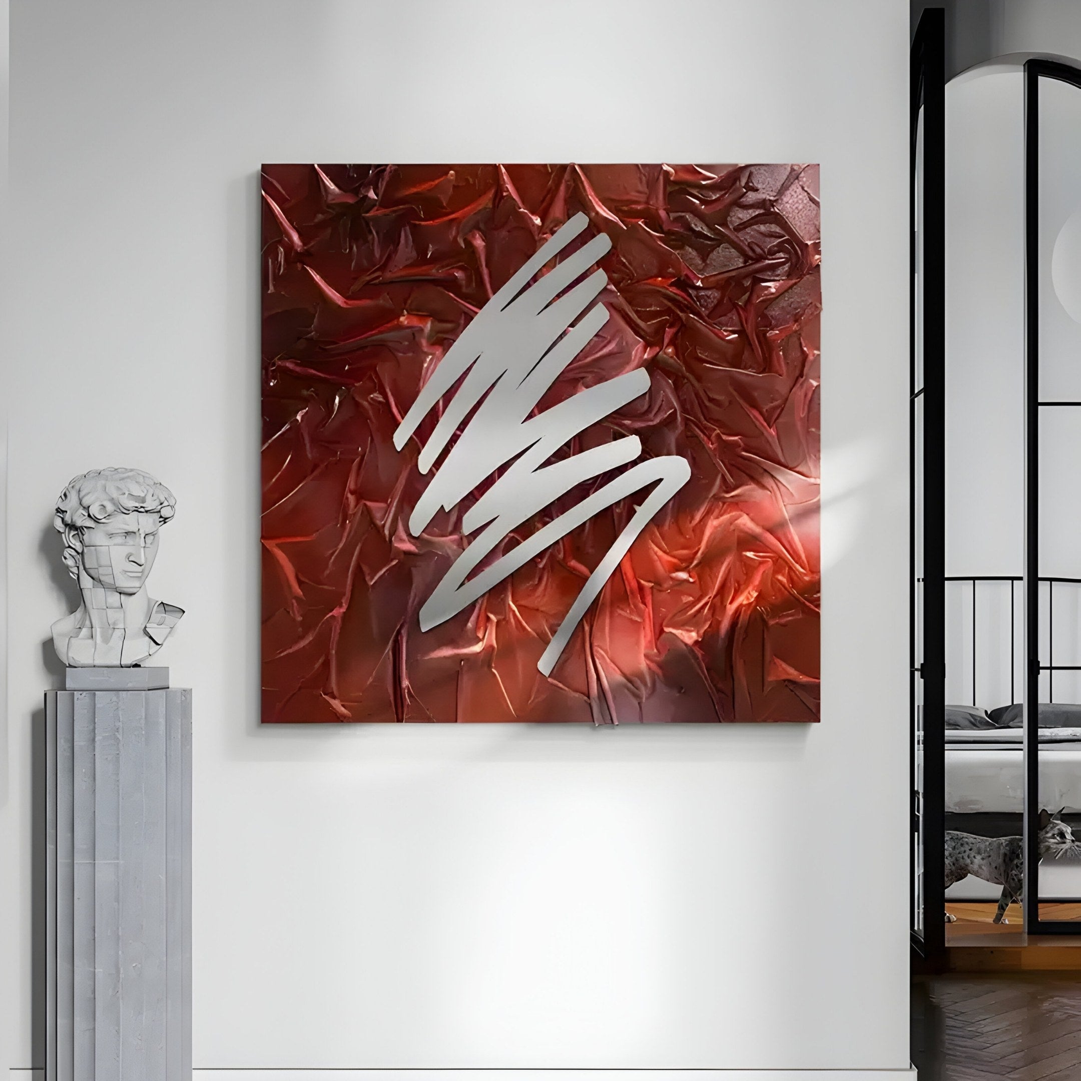 A contemporary interior features Giant Sculptures Plisse Crimson Red Textured Abstract Wall Art with silver brushstrokes on a white wall. Nearby, a classical-style bust rests on a pedestal, while a minimalist bedroom is visible in the background.