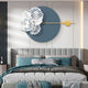 A modern minimalist bedroom features Giant Sculptures Blossom Halo Ocean Grey Round Floral Decorative Wall Art, showcasing blue circles with white floral elements and a gold accent. The bed has teal and gray bedding with two checkered pillows, while soft lighting creates a serene atmosphere.