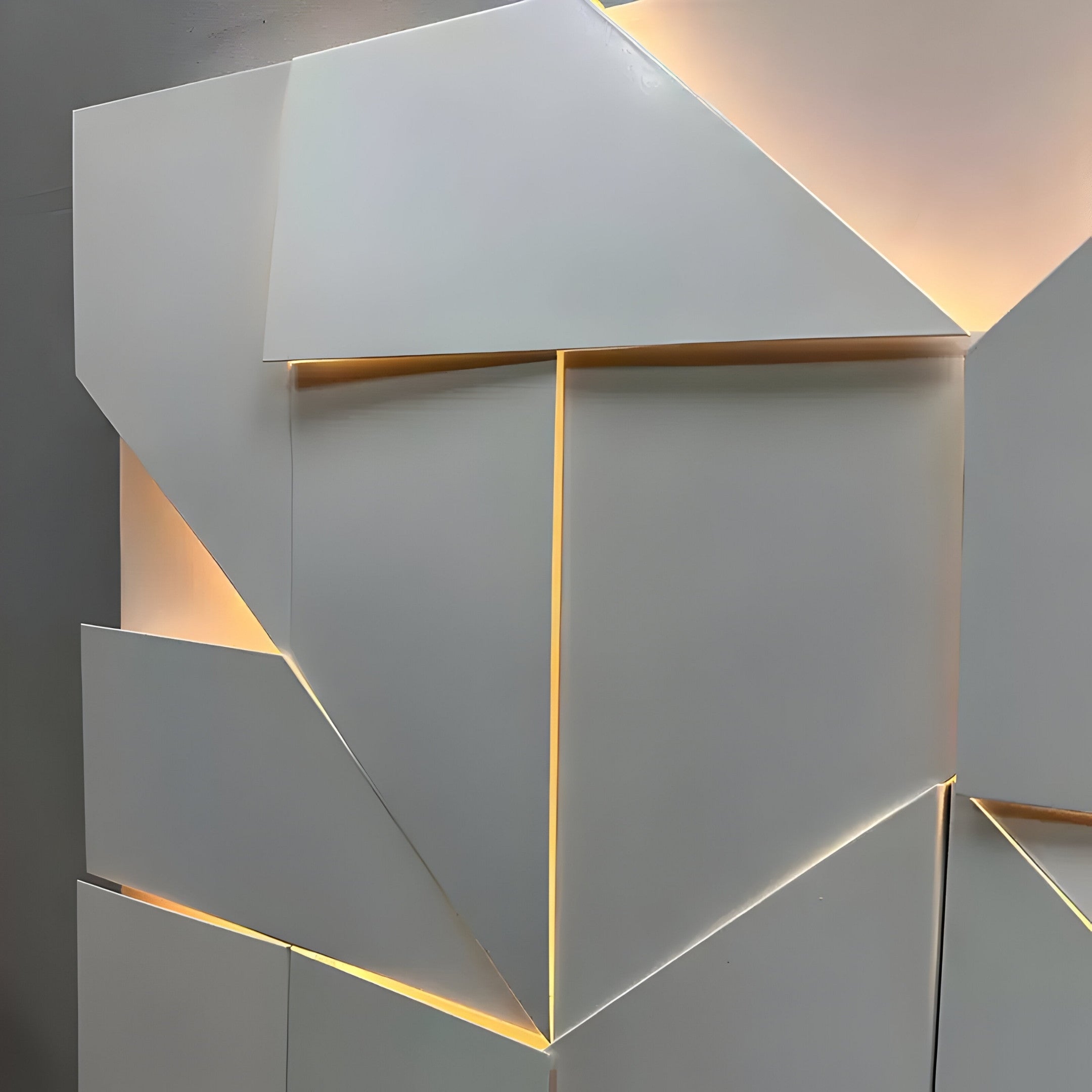 The Prisma White Geometric Panel 3D Wall Art by Giant Sculptures features overlapping white panels with warm ambient lighting. This minimalist decor offers a striking abstract geometric effect and sophisticated visual appeal.