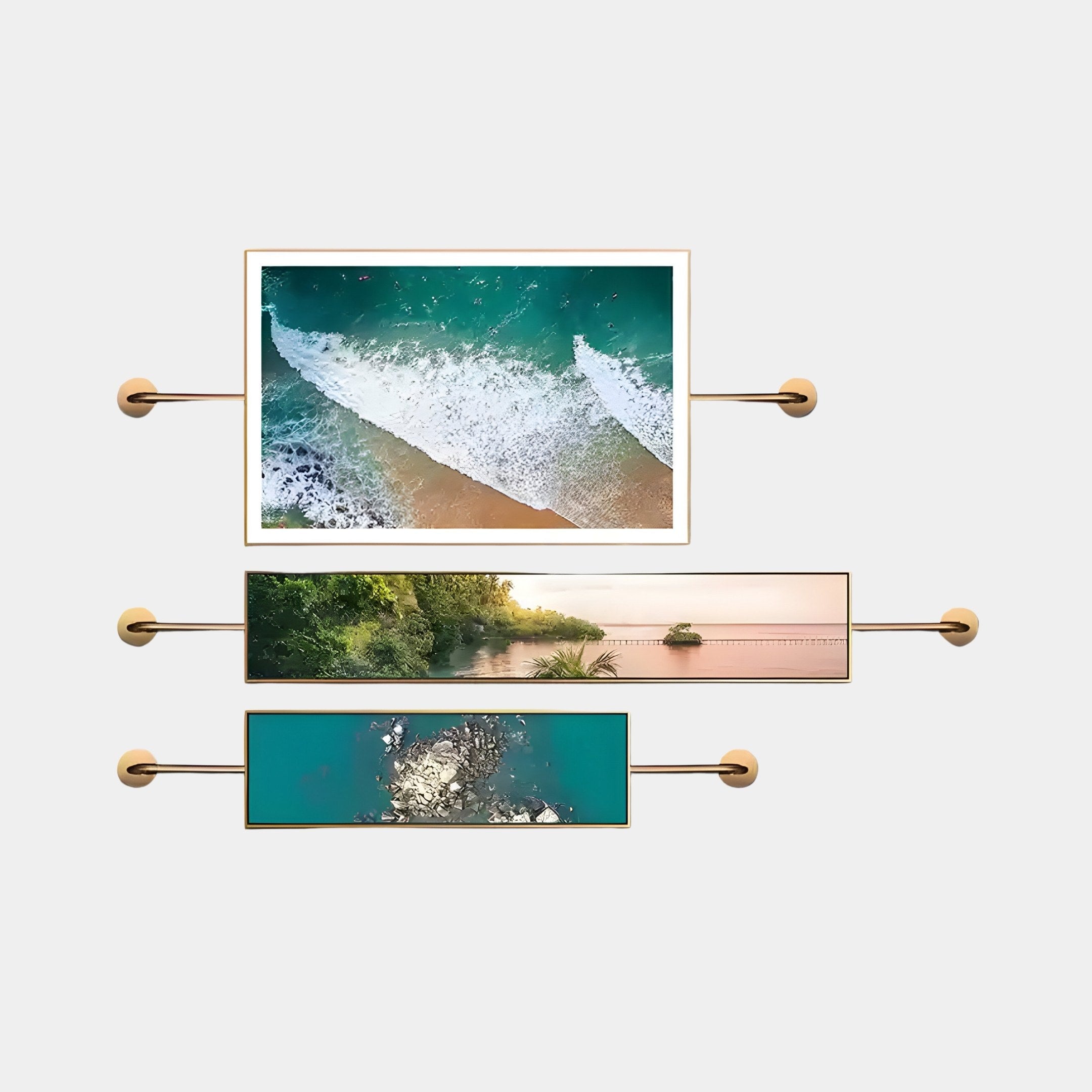 The Visario Ocean & Nature Inspired Metal Wall Art by Giant Sculptures comprises three horizontally mounted framed photographs with coastal themes: ocean waves, a serene river, and a turquoise water splash. Each frame includes gold accents and rod-like stands.