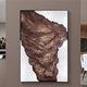 The Terranica Rustic Earth-Toned Textured Abstract Metal Wall Art by Giant Sculptures hangs elegantly on the wall, showcasing layers of brown and rust colors that evoke a geological formation or draped fabric in a modern interior.