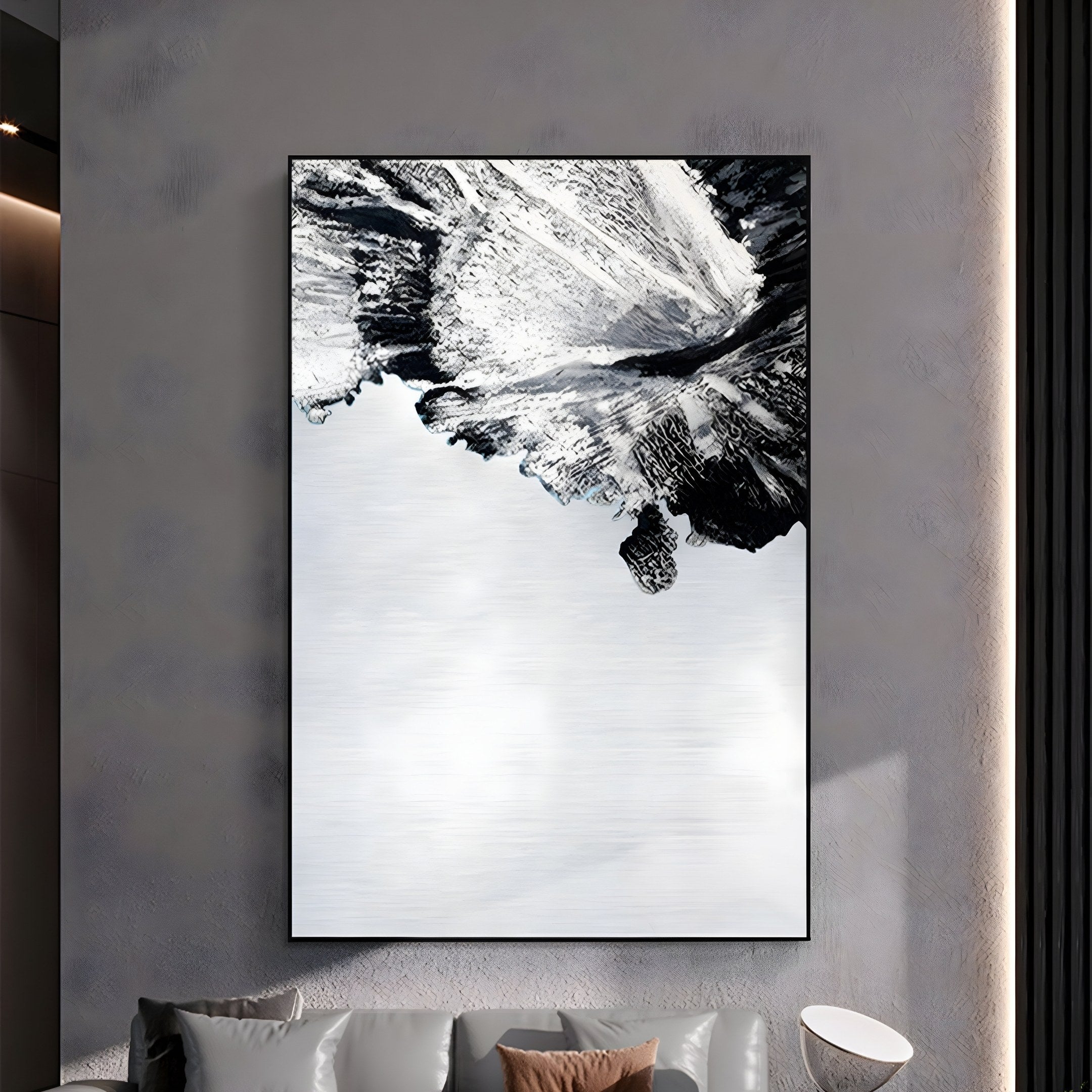 The Terranica Monochrome Flow Textured Abstract Metal Wall Art by Giant Sculptures is a stunning piece featuring an inverted landscape of snowy mountains and a cloudy sky. Ideal for modern living rooms, it hangs above a light sofa with round white side tables, adding elegance to the space.