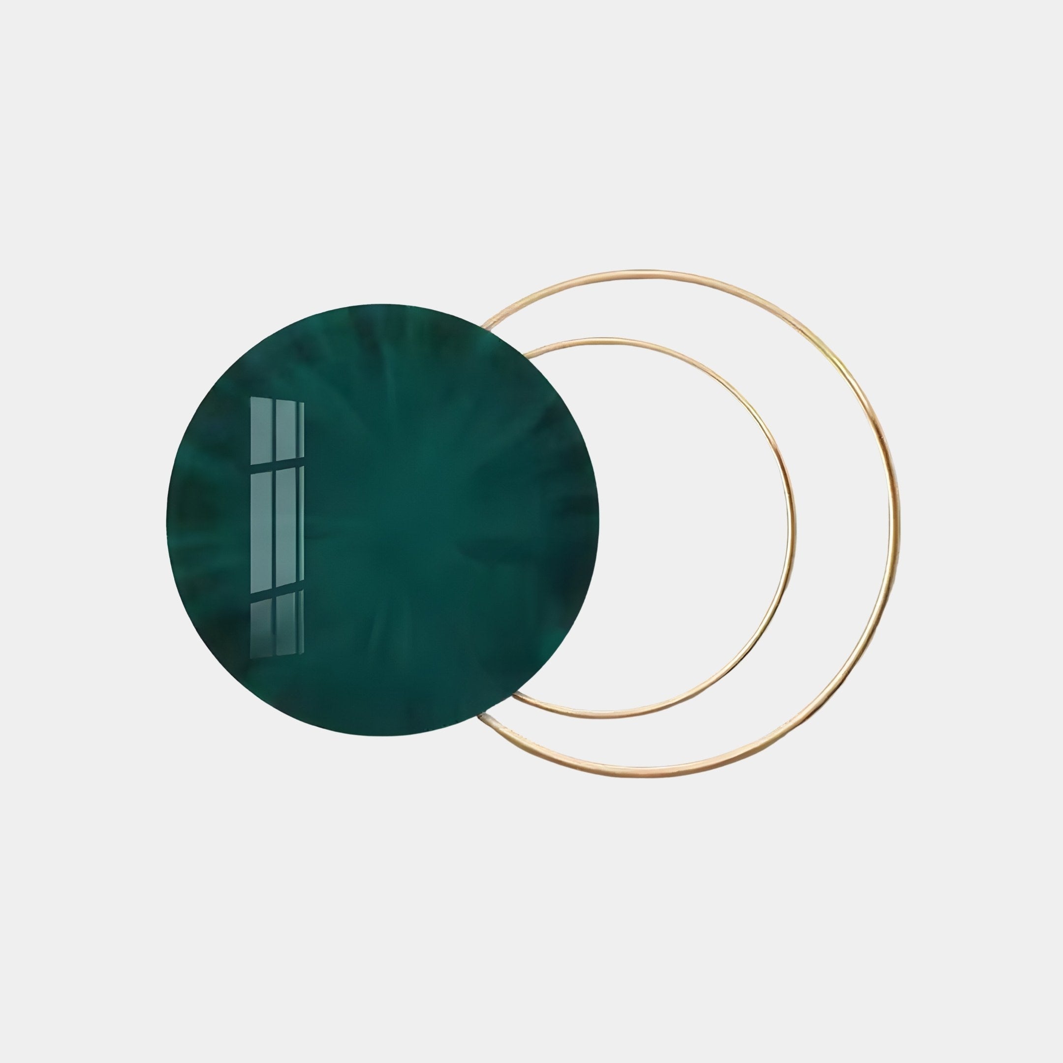 The Eclipse Luxe Velvet Emerald Circular Ring Wall Art by Giant Sculptures features a large dark green circle slightly overlapping two thin gold rings on a light gray background, with a window reflection adding depth to this contemporary decor piece.