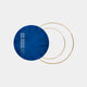 The Eclipse Luxe Midnight Blue Circular Ring Wall Art by Giant Sculptures, featuring a reflective surface, is placed in front of two gold rings on a neutral background. The blue circle reflects a window, crafting an artistic minimalist design ideal for contemporary interiors.