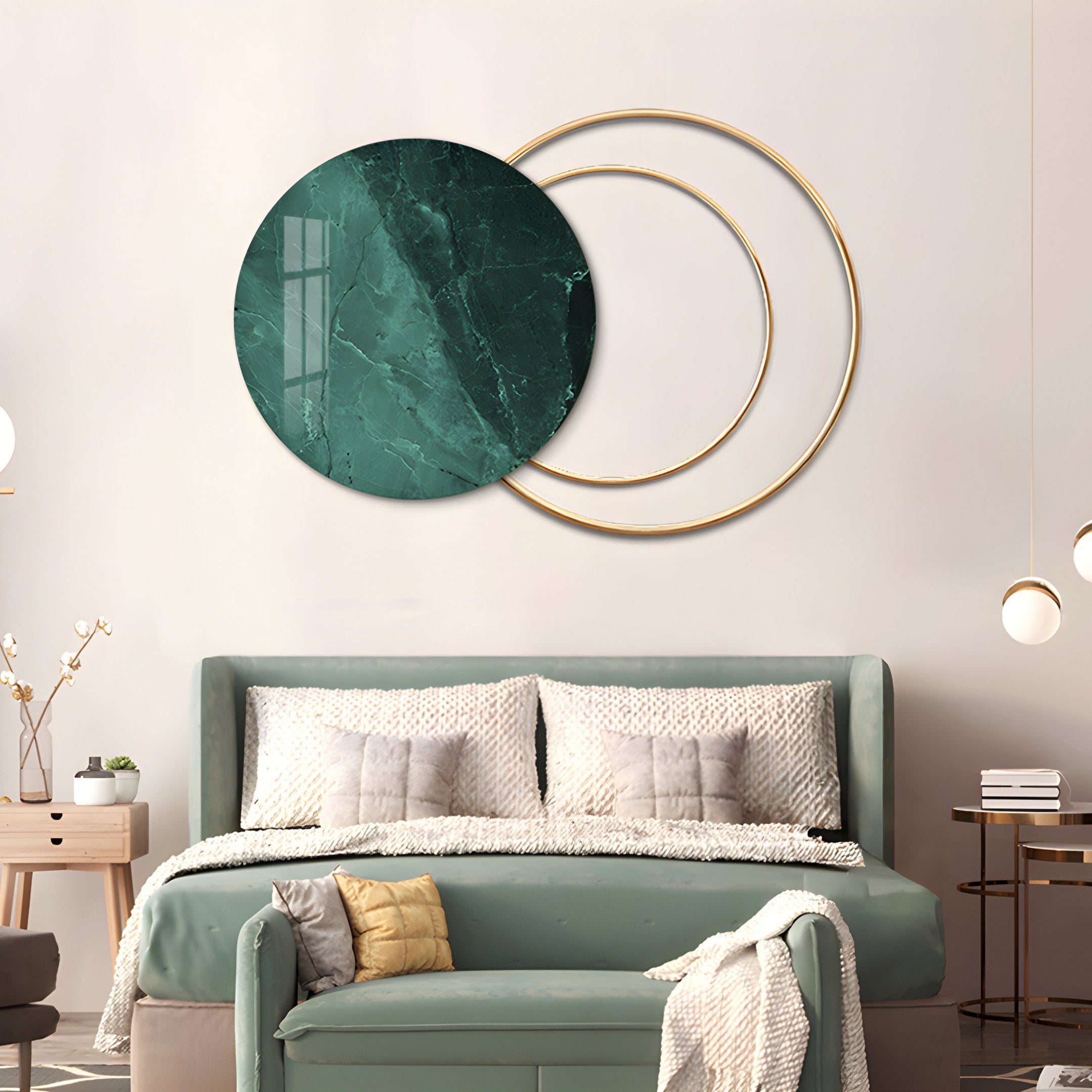 A modern bedroom features a light green bed with textured pillows and a soft throw. Giant Sculptures Eclipse Luxe Noir Marble Green Circular Ring Wall Art adds elegance above. A wooden side table nearby holds a vase.