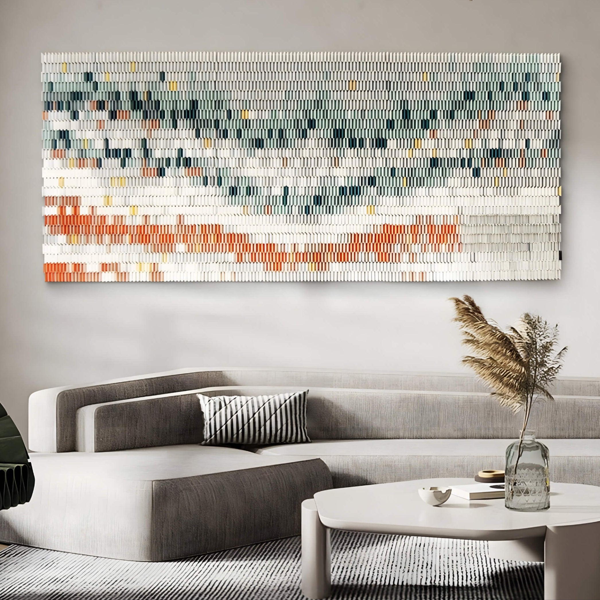 Large-scale horizontal ceramic wall art installed above a modern sectional sofa. The piece features green, orange, and cream tones, adding texture and visual interest to a minimalist living space.