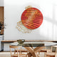 A modern dining area features a wooden table with chairs, complemented by the Auramesh Crimson-I Metal Winged Circular Geometric Wall Art from Giant Sculptures, showcasing a gold geometric overlay on a red circular backdrop. A glass bowl and a plant enhance the spaces appeal.