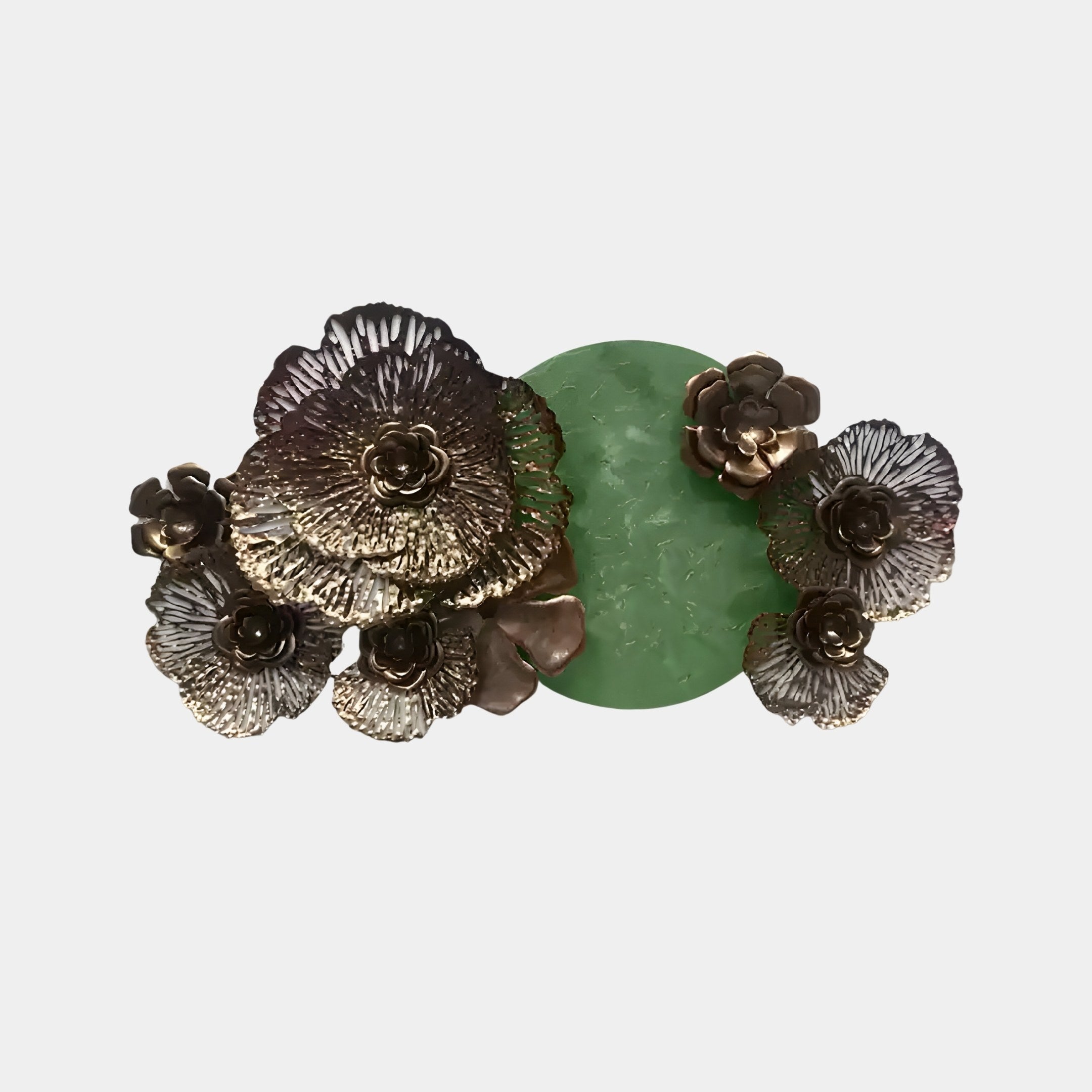 The Luminis Bloom Green Floral Metal Wall Art by Giant Sculptures is a modern design masterpiece, featuring large bronze flowers with intricate petal details that contrast sharply against a smooth, textured green circle at the center.