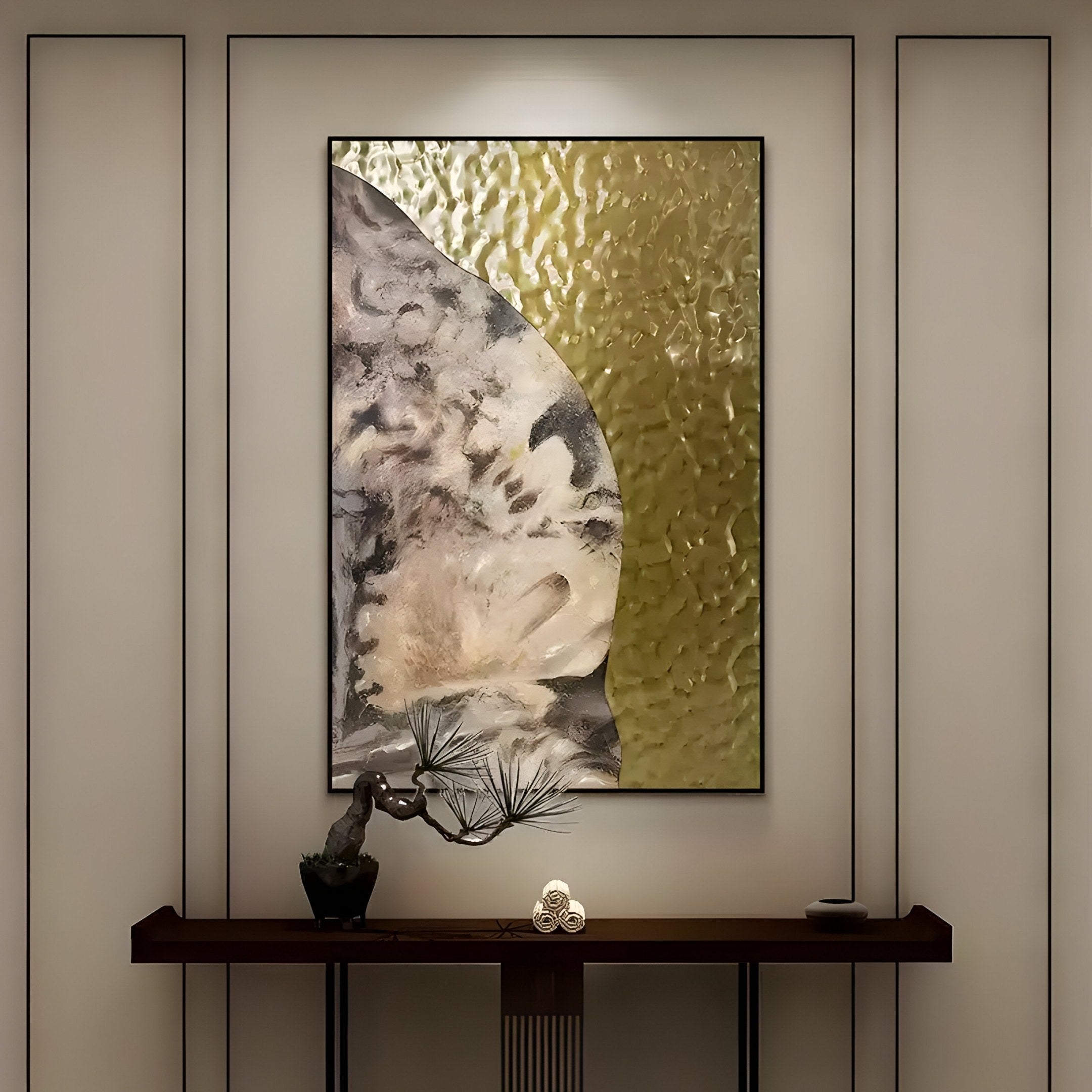 In a minimalist room, the Astrid Earthy Bloom Gold Textured Abstract Wall Art by Giant Sculptures adorns the wall with gray tones. Below, a wooden console table supports a small bonsai tree and a decorative object. Soft lighting enhances the tranquil ambiance.