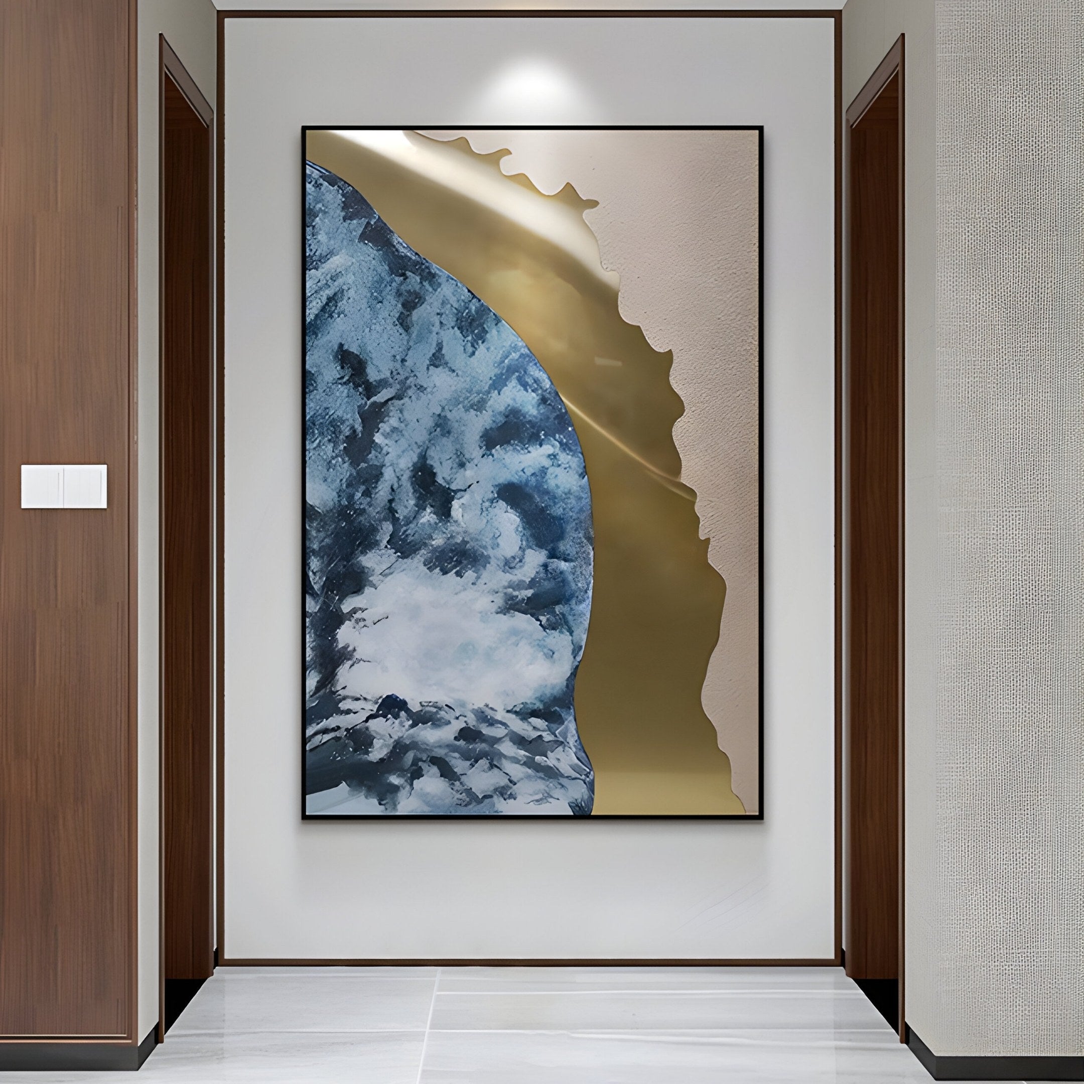 The Astrid Azure Flow Gold Abstract Wall Art by Giant Sculptures, with blue, gold, and white swirls and a hand-painted oil finish, enhances a modern hallway adorned with wooden walls and a marble floor.