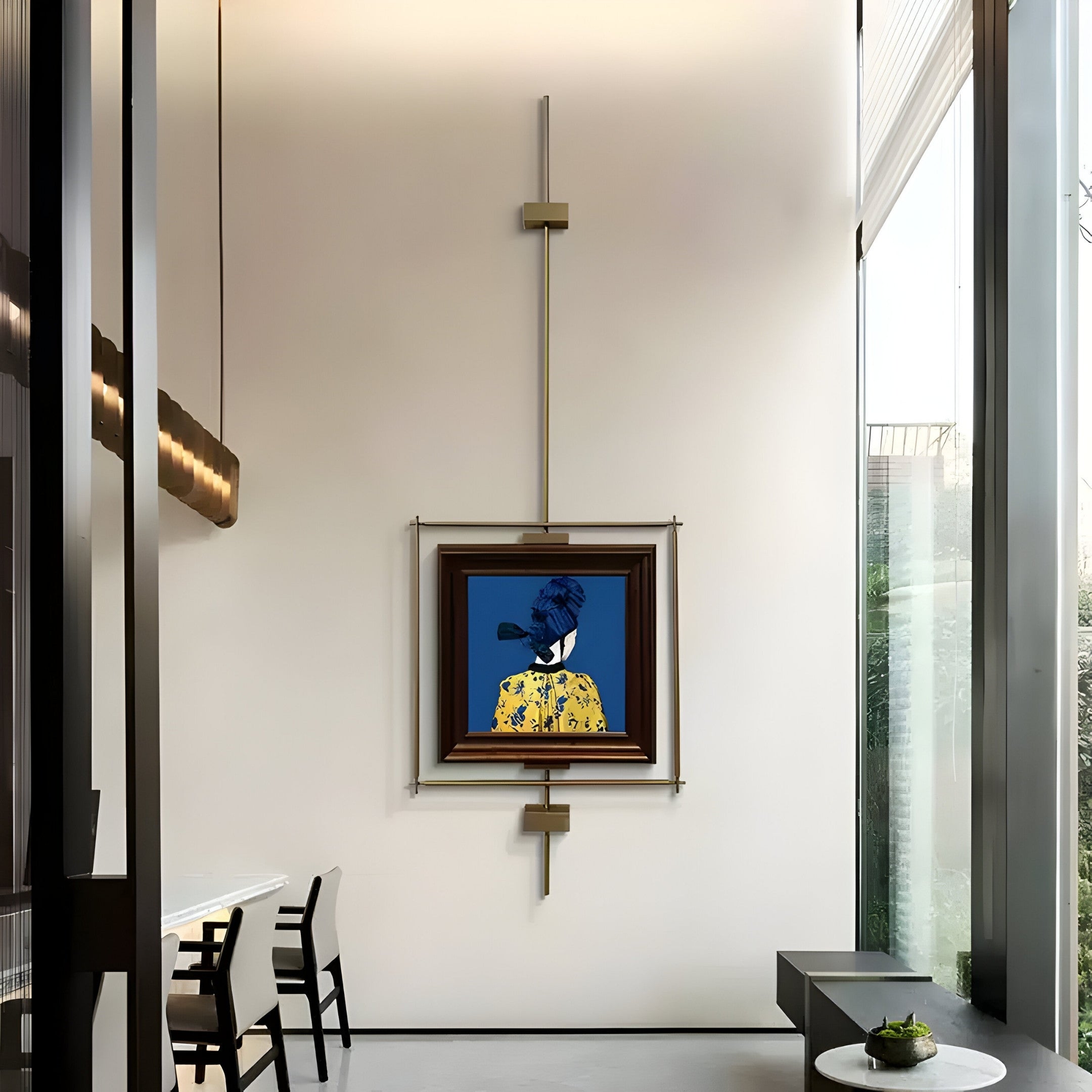 The room exudes sophistication with minimalist furniture, tall windows, and sleek design elements. It features Giant Sculptures Ethereal Frames Regal Blue Portrait Suspended Wall Art showcasing a colorful painting of a person in a patterned yellow outfit and blue hat.