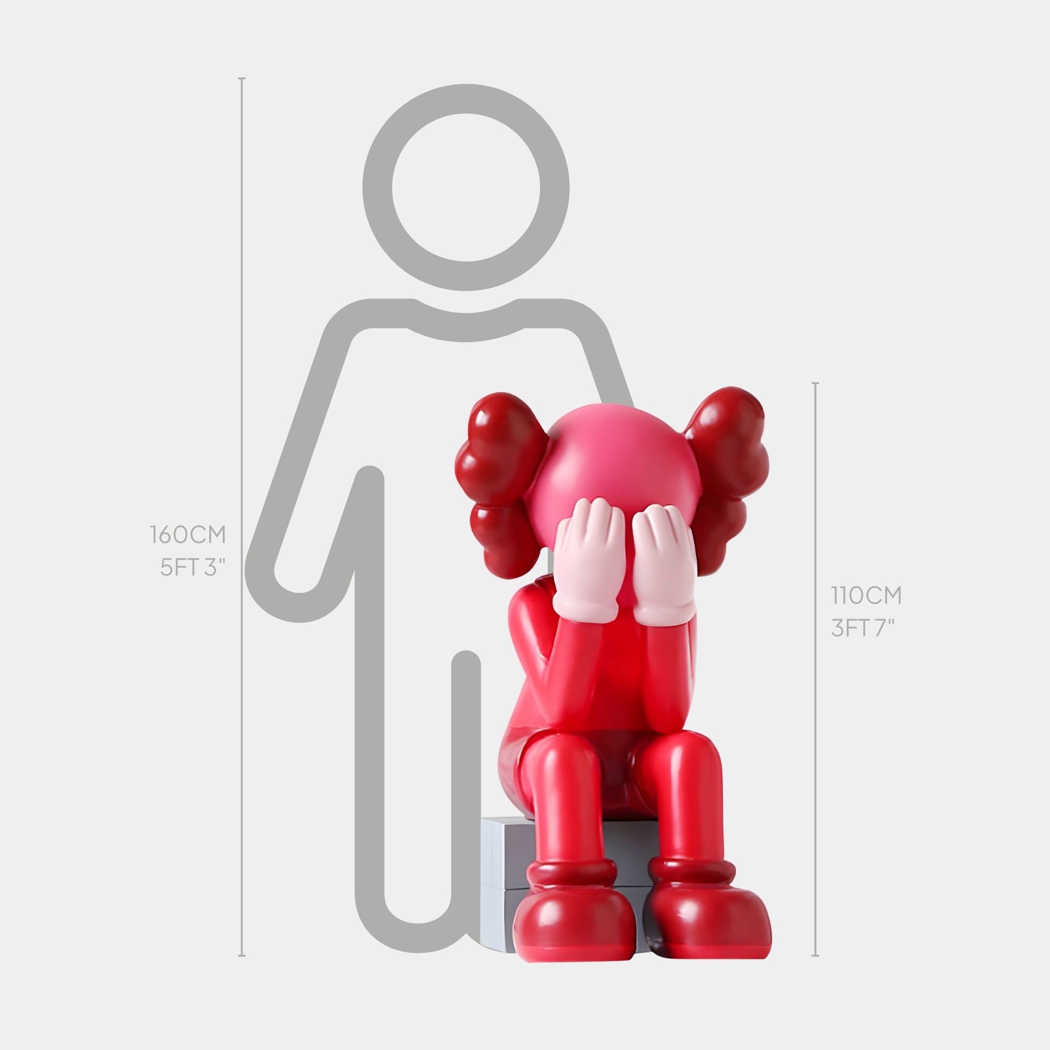 The Blush Ruby Iconify Melancholy Sitting Sculpture by Giant Sculptures features a 110cm red and pink figure seated on a gray block, hiding its face. A 160cm gray silhouette stands behind, contrasting with the sculptures contemporary sophistication.