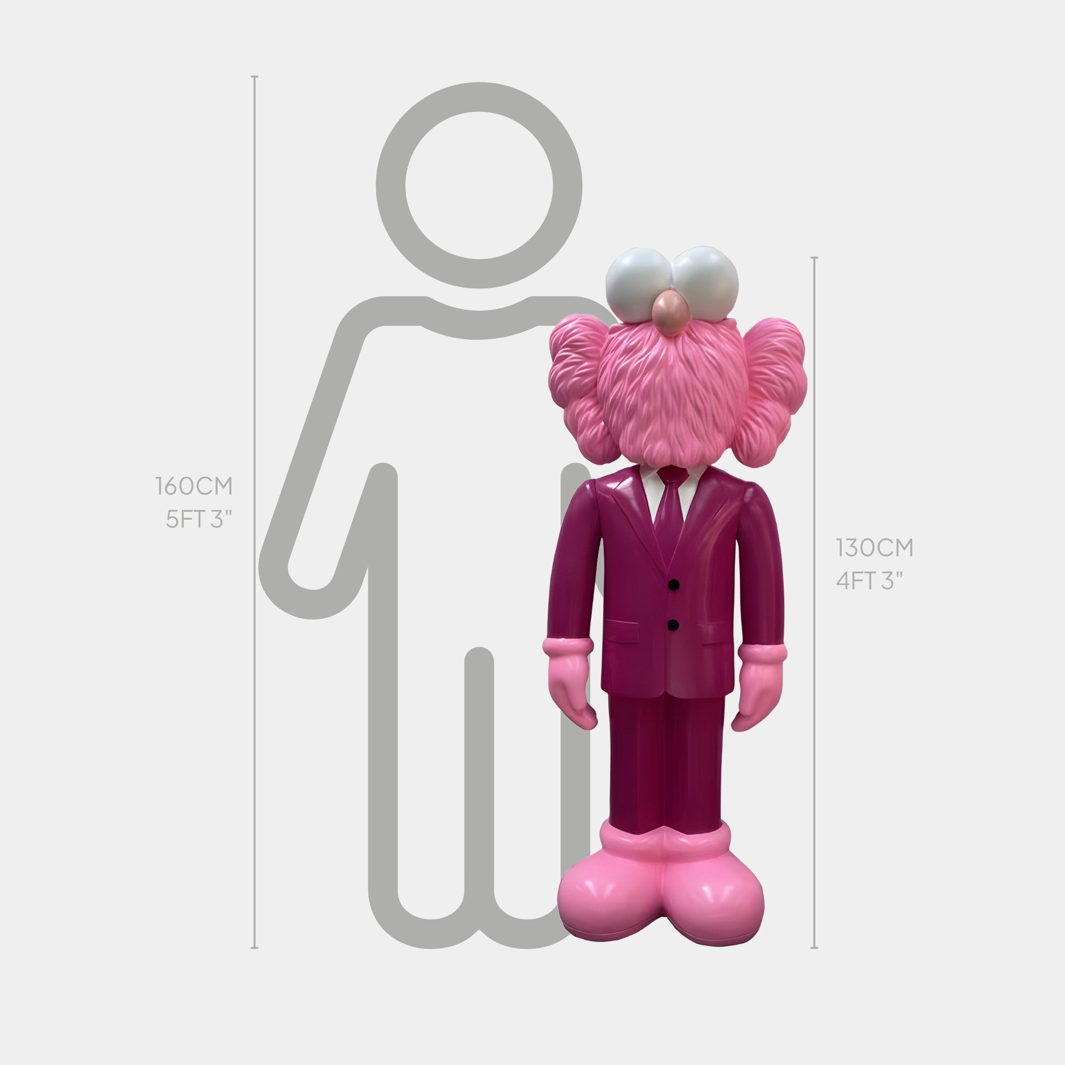 The Deep Magenta Suit Iconify CEO Sculpture by Giant Sculptures is a pink cartoon figure, 130 cm (4 ft 3 in) tall, placed beside a height chart with a human outline marked at 160 cm (5 ft 3 in).