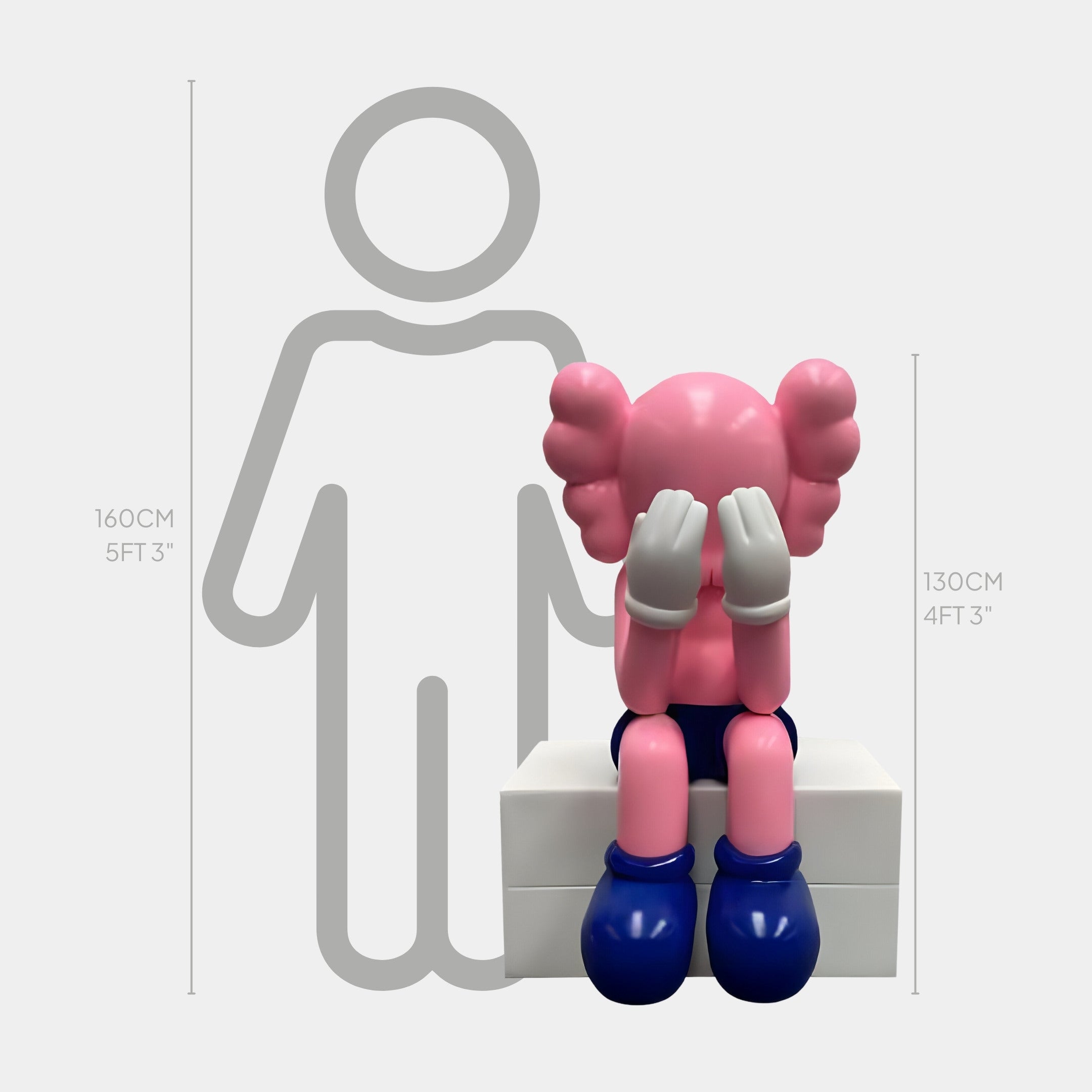 The Pedal Pink Iconify Melancholy Sitting Sculpture by Giant Sculptures features a cartoon figure with pink hair, gray arms, and large blue shoes, sitting on a white block at 130 cm tall alongside a 160 cm outlined humanoid shape, showcasing modern pop-art flair.