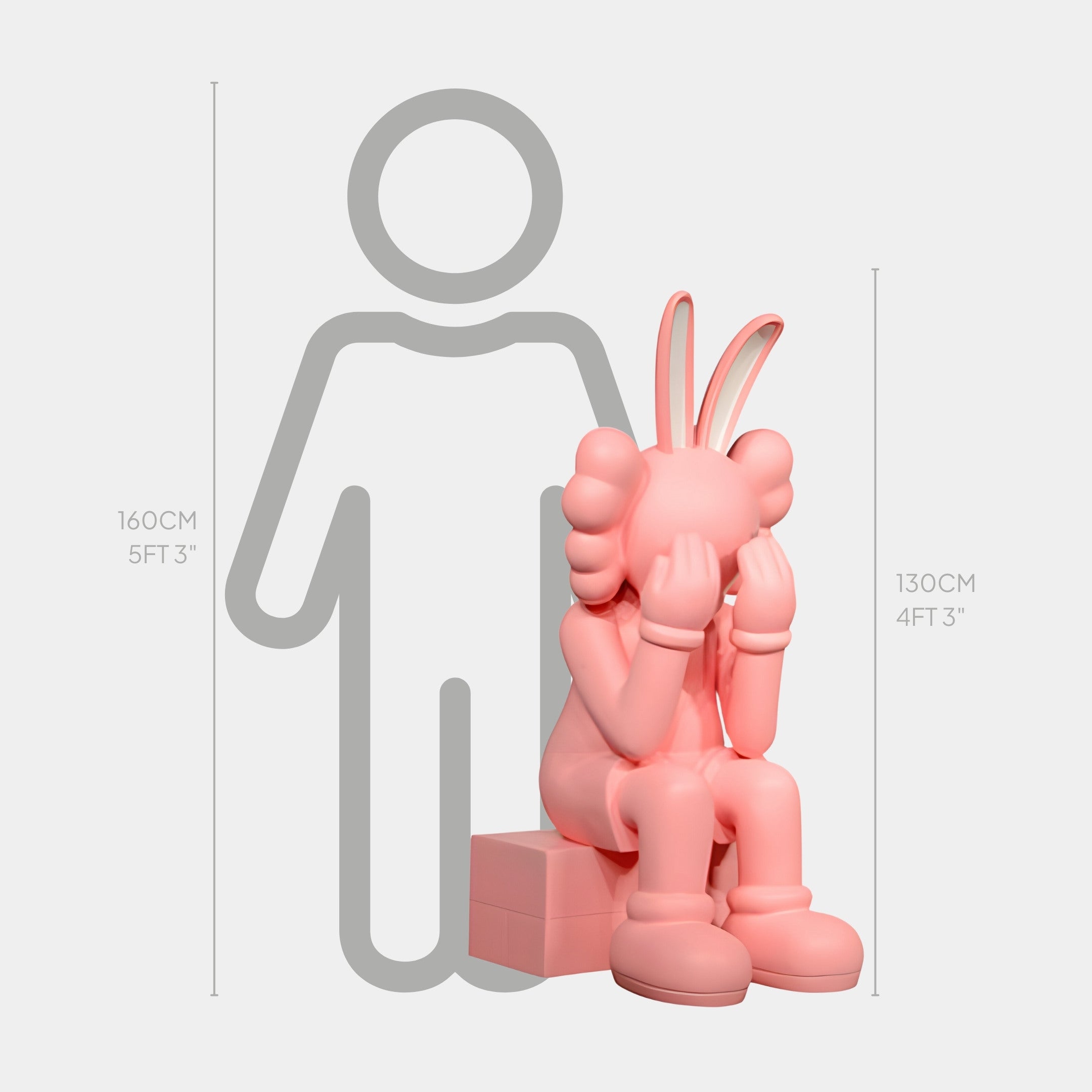 The Coral Pink Iconify Melancholy Rabbit Sitting Sculpture by Giant Sculptures, 130 cm tall, portrays a cartoon-like figure sitting with its face in gloved hands. In pastel pink with a faint grey human outline behind for scale, its perfect for contemporary spaces and design enthusiasts.