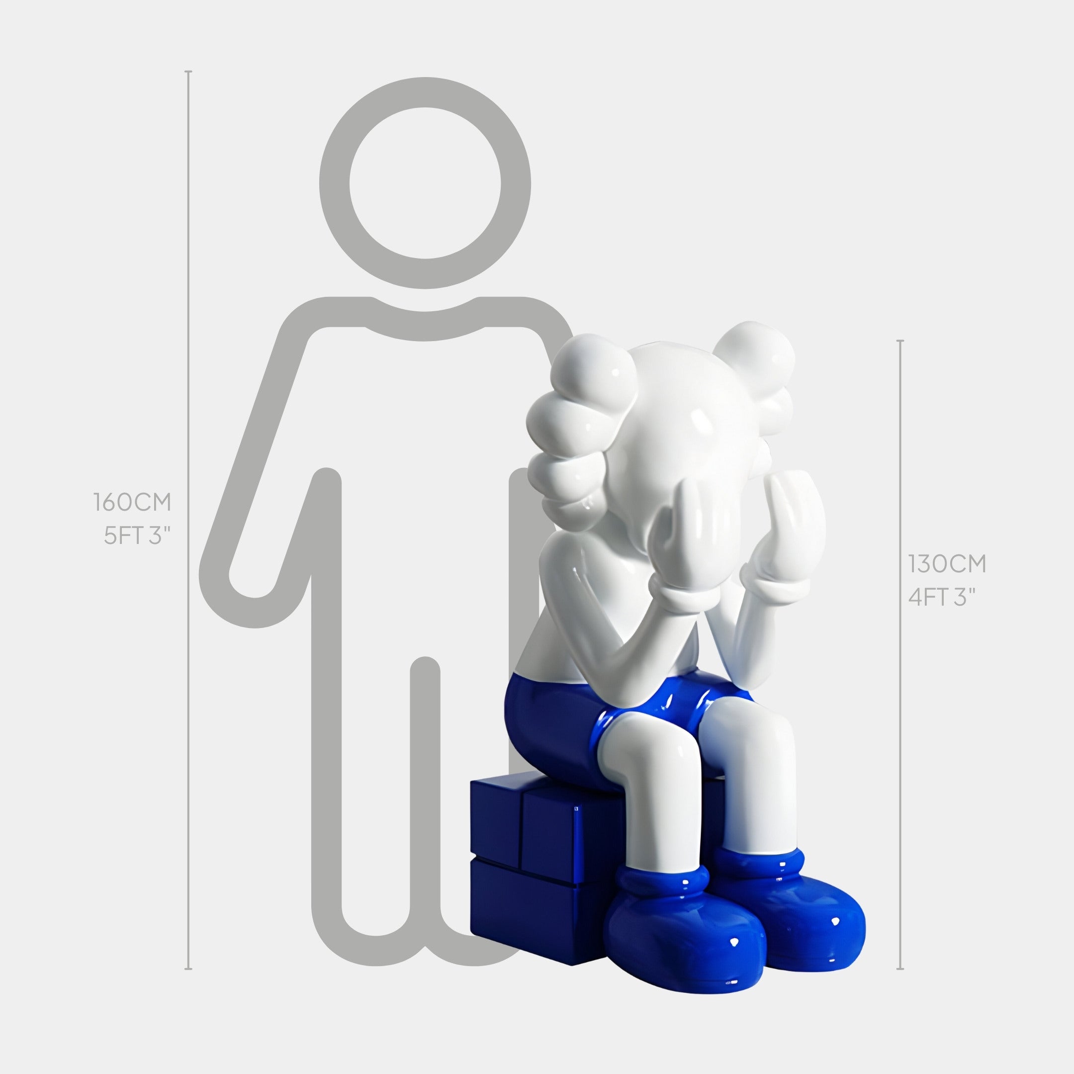 The White & Blue Iconify Melancholy Sitting Sculpture by Giant Sculptures is a contemporary, minimalist piece featuring a seated figure with a white head and hands. Dressed in blue pants and shoes, it rests on a blue cube and measures 130cm beside a 160cm human outline for scale.