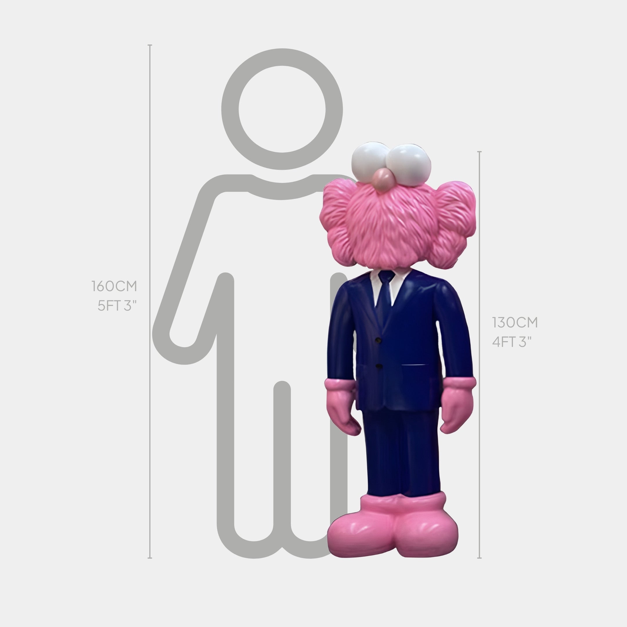 The Giant Sculptures Iconify CEO features a pink cartoon figure in a deep navy blue suit standing at 130 cm tall beside a gray 160 cm human silhouette, capturing modern pop arts playful take on scale and identity.