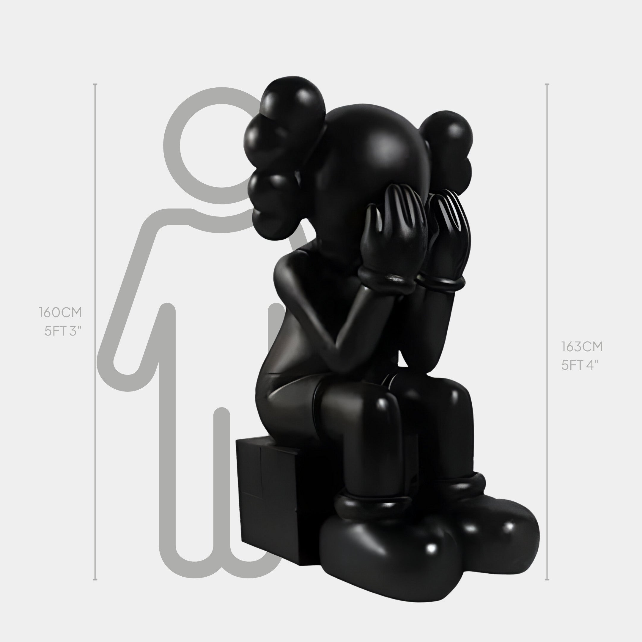 The Midnight Black Iconify Melancholy Sitting Sculpture by Giant Sculptures stands at 163cm and features a seated figure with gloved hands covering its face. It has round shapes on the head resembling hair, and a faint silhouette behind adds depth, making it perfect for luxury interiors.