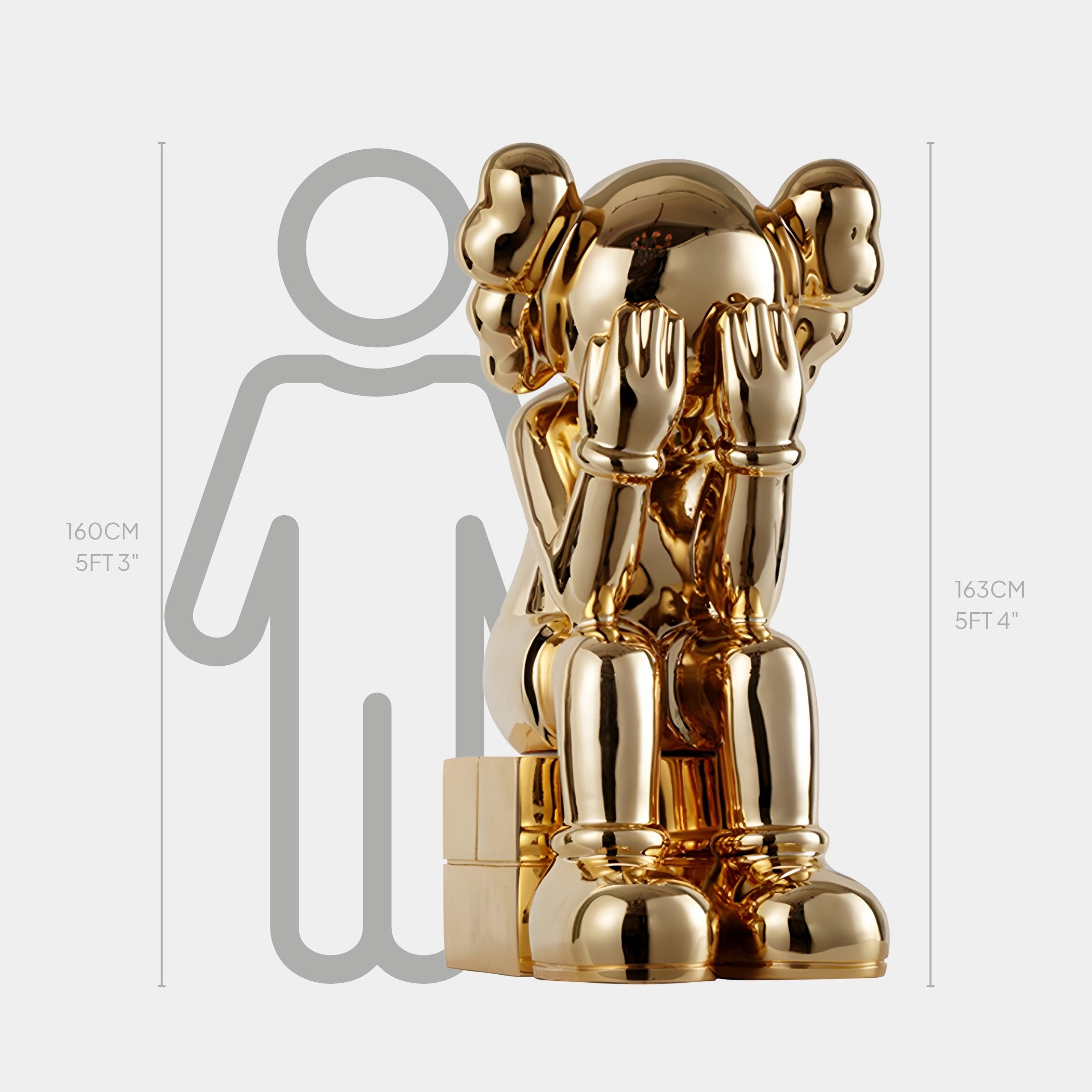 The Antique Gold Iconify Melancholy Sitting Sculpture (163cm) by Giant Sculptures features a whimsical, cartoon-like figure with hands covering its face. Its emotive artistry adds luxury to interiors, perfectly offset by a grey silhouette for scale.