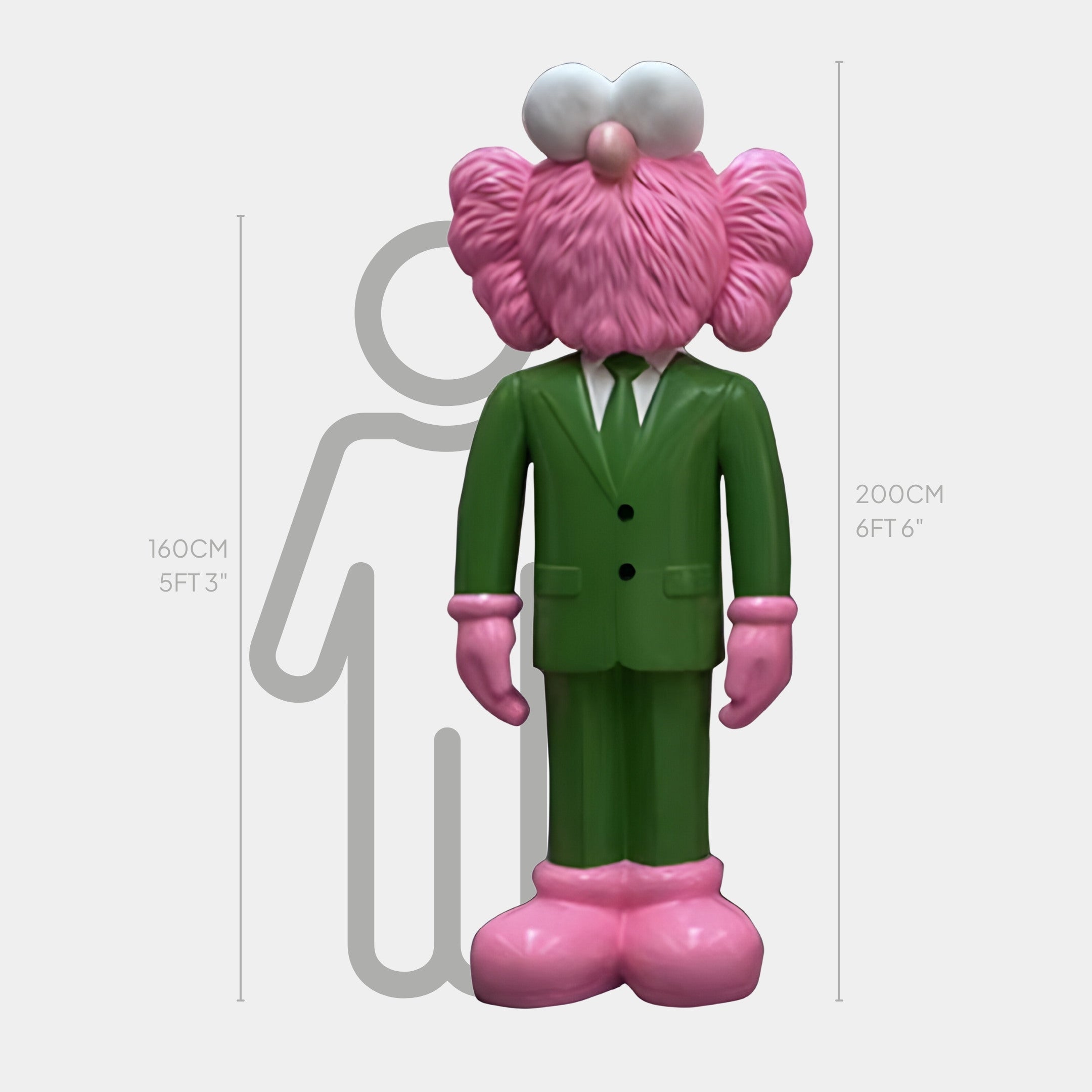 The Forest Green Suit Iconify CEO Sculpture by Giant Sculptures is a 200 cm pink, fluffy cartoon character. Next to it stands a 160 cm gray outline of a person. Featuring heart-shaped eyes and oversized pink shoes, this whimsical design brims with charm.