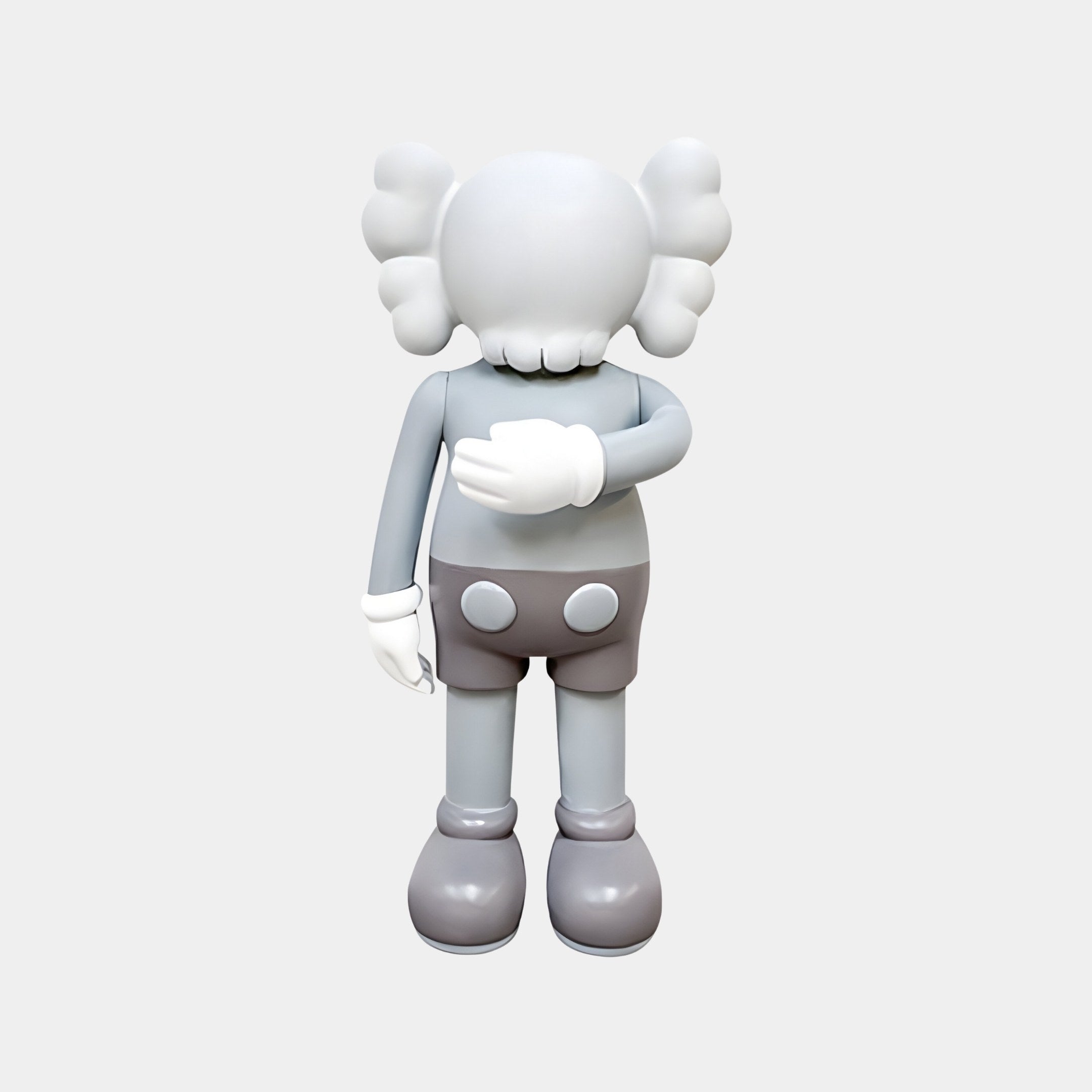 The Soft Grey Iconify II Dance Sculpture by Giant Sculptures, standing 70cm tall, features a gray cartoon figure with round ears and gloves facing away. The minimalist design in soft gray and white blends seamlessly with modern interiors for an elegant touch.