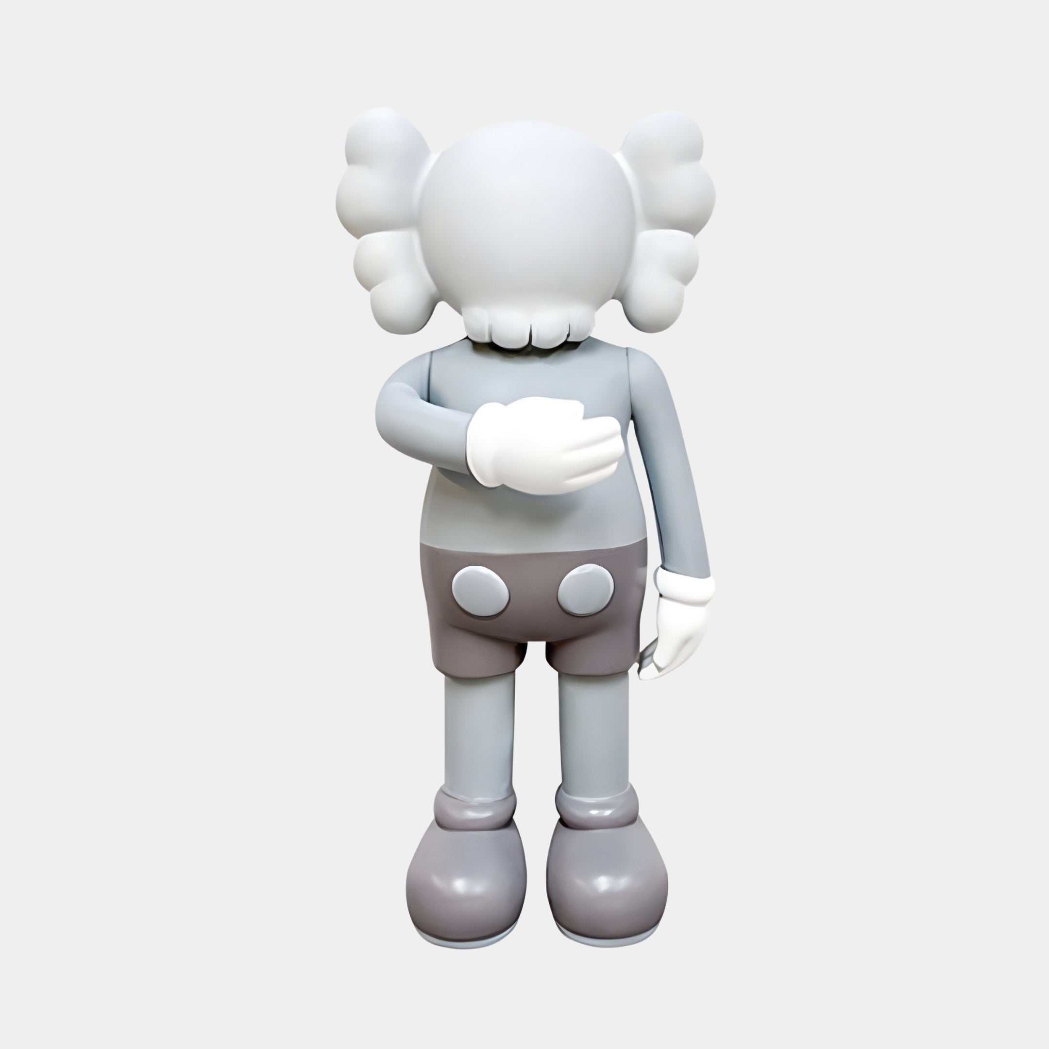 The Soft Grey Iconify V Dance Sculpture - 70cm by Giant Sculptures features a smooth, minimalistic gray cartoon-like figure with large, puffy ears facing away, wearing gloves and buttoned shorts. Its arm covers its chest in a contemporary artistic gesture against a light background.