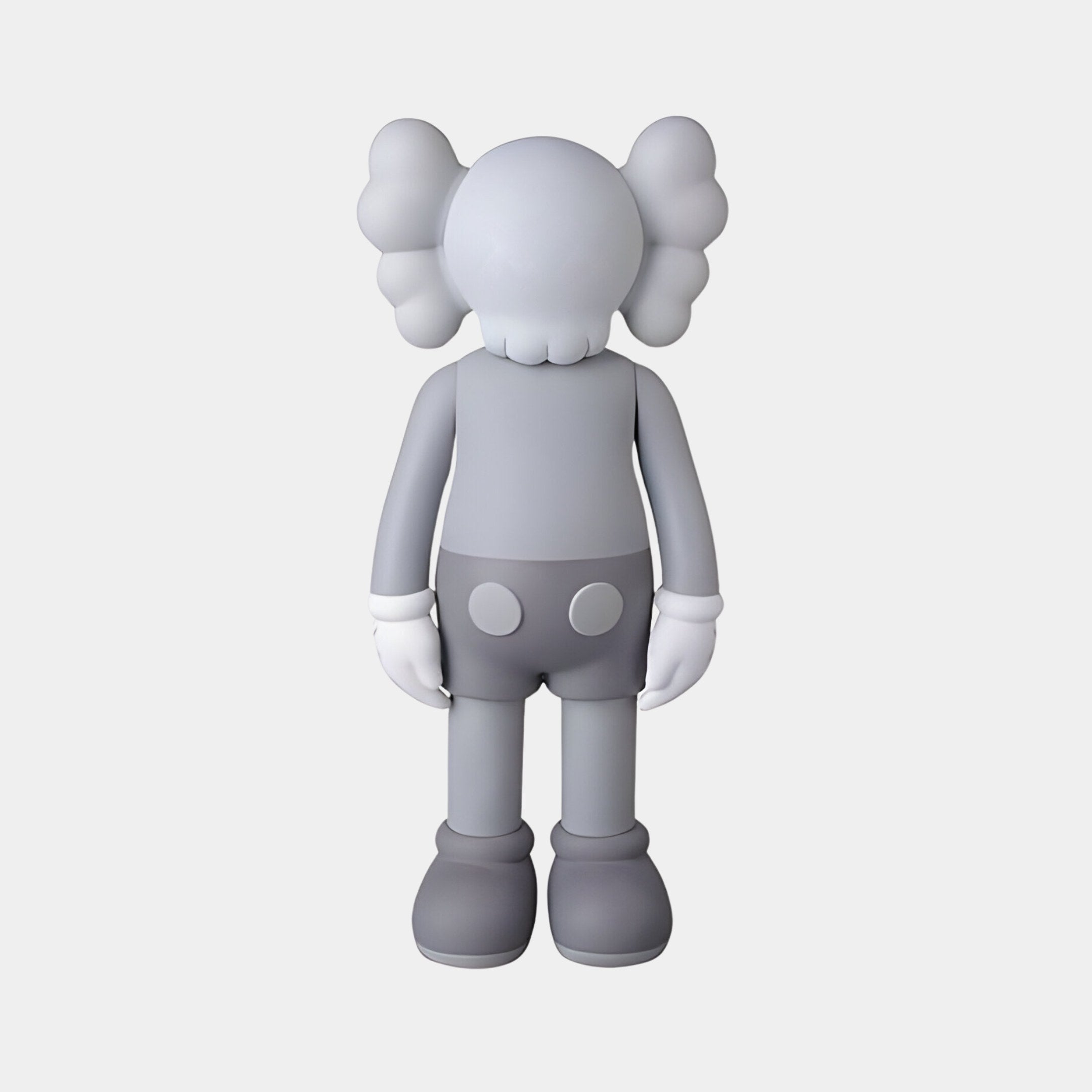 The Slay Grey Iconify Standing Sculpture by Giant Sculptures is a contemporary 70cm gray cartoon figure with thick limbs and a polished resin finish. It features cloud-like ears, X face details, gloves, and two white circles on its back, set against a plain white background.