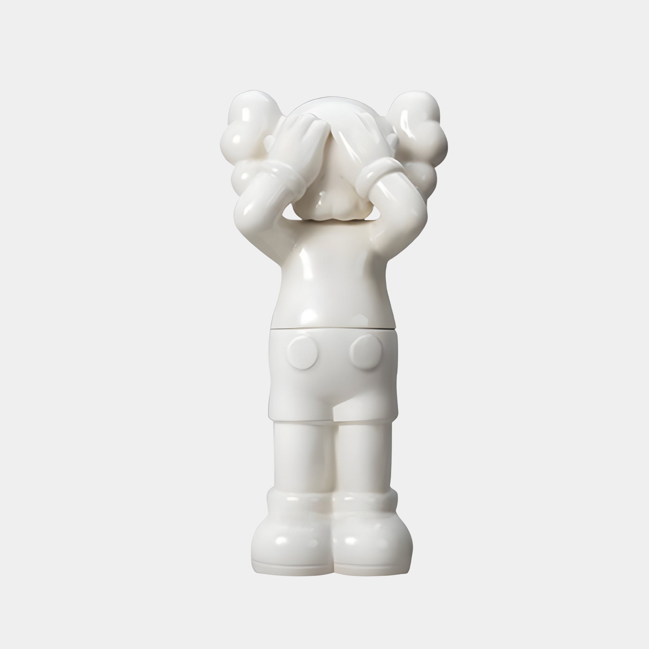 The Cloud White Iconify Silent Cry Sculpture by Giant Sculptures features gloved hands shielding its face, bulbous hair, and large shoes. This 91cm minimalist piece resembles a cartoon-style figure against a plain background.