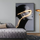 A modern living room radiates contemporary elegance, showcasing the Sylva Radiant Grace Canvas 3D LED Wall Art by Giant Sculptures featuring a black-and-white womans profile with a glowing yellow line. A gray and black-patterned sofa is in the foreground, flanked by a gold floor lamp.