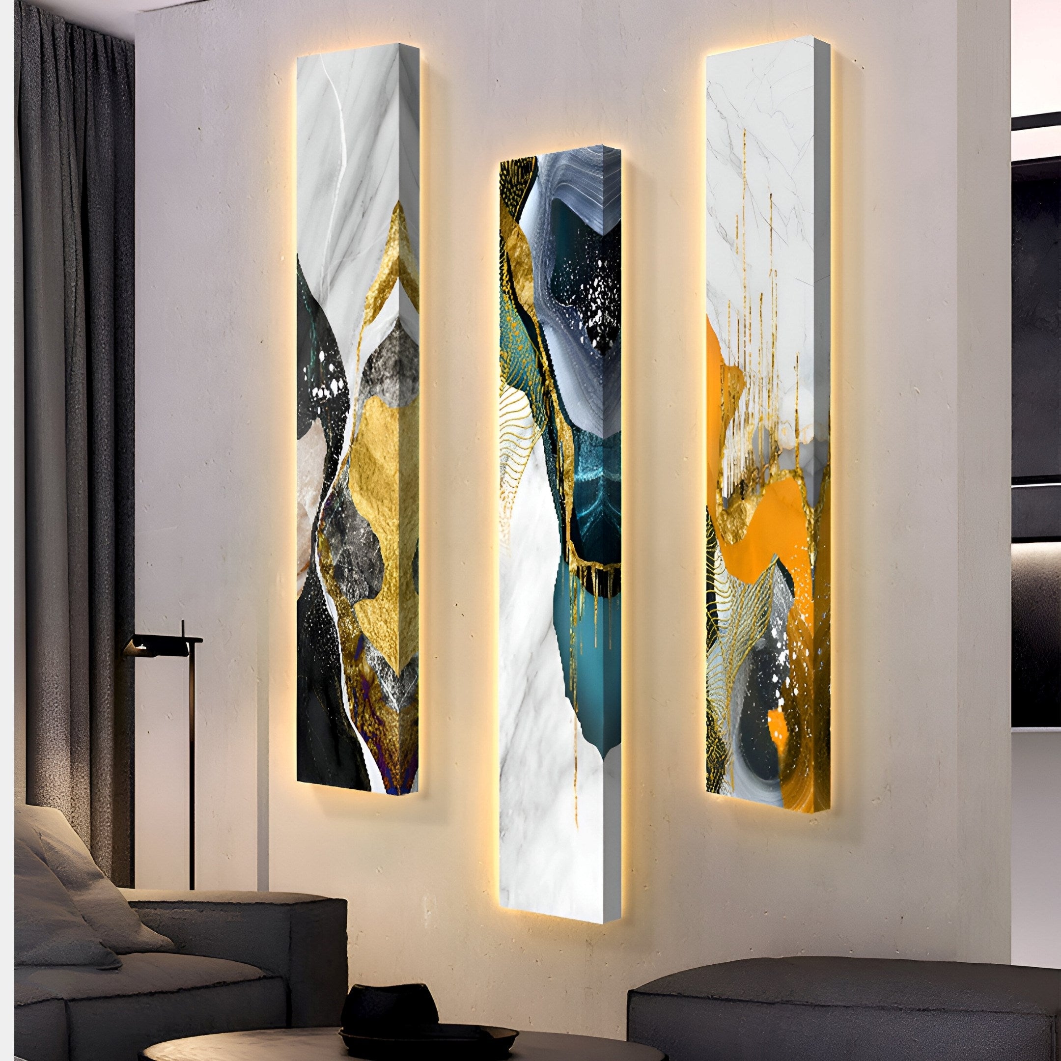 The Floren Golden Veil Canvas LED Wall Art by Giant Sculptures, featuring gold, teal, black, and white hues with subtle floral motifs, hangs in a minimally furnished room. Each piece exudes a serene glow above a sleek sofa.