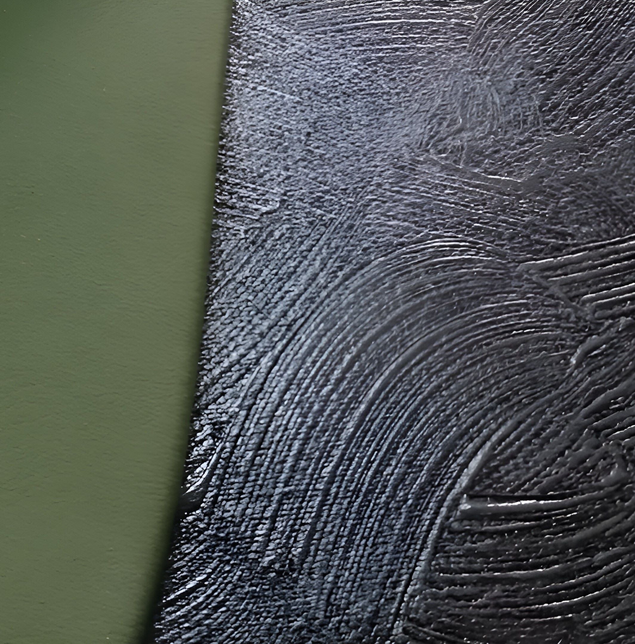 A close-up reveals Giant Sculptures Gleam Olive Serenity 3D Leather LED Wall Art, showcasing hand-painted olive tones on the left and dark ridged patterns on the right. This contrast enhances intricate brushstroke-like marks, creating a calming vibe in the dark space.