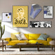 A living room includes a bright yellow sofa with striped pillows, a modern wooden coffee table, and a tall cactus. The walls feature Giant Sculptures Orison Noir Harmony UV Wood 3D Wall Art alongside abstract art and black-and-white photos for an artistic ambiance.