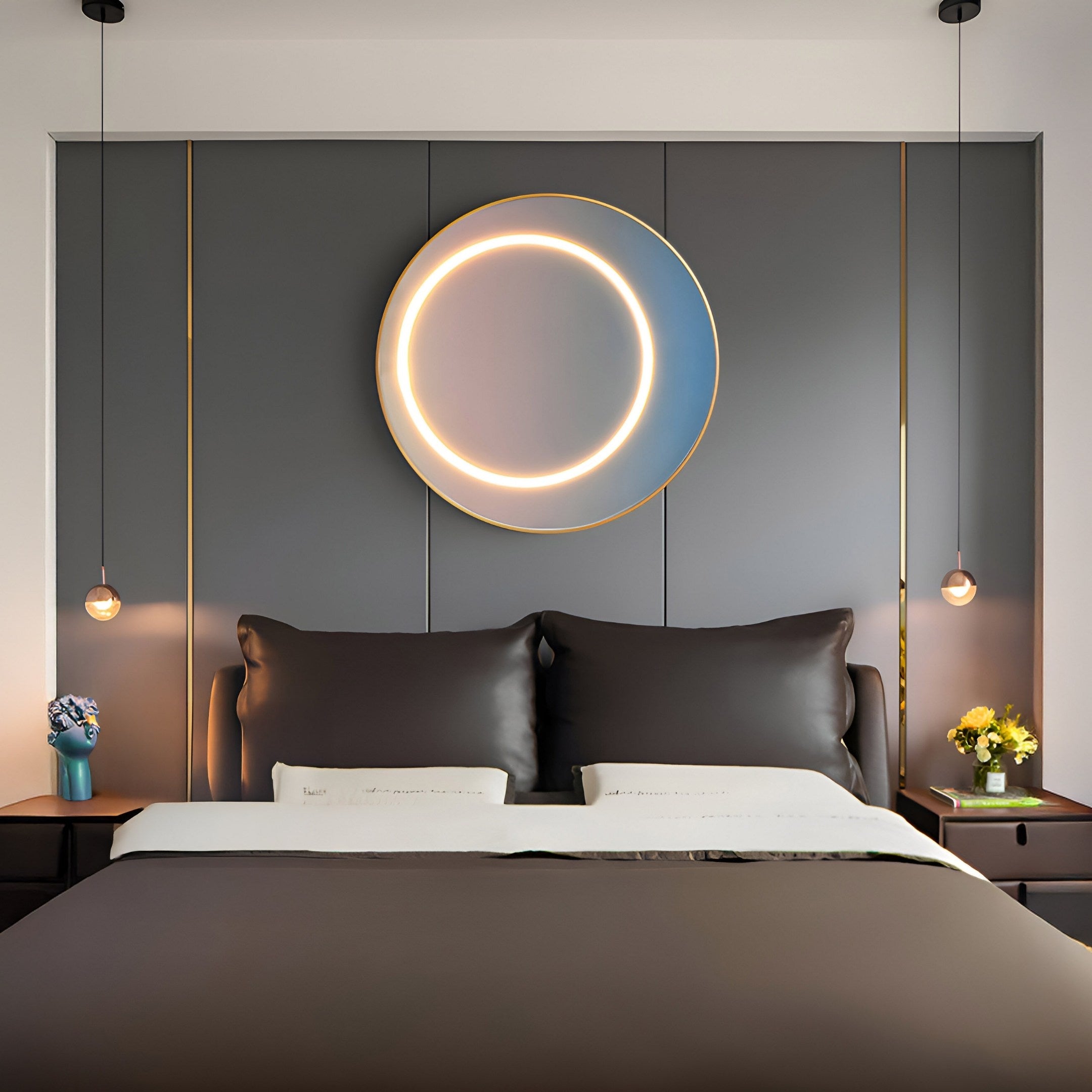 A modern bedroom showcases a large bed with gray bedding and two pillows. Above, the Aurora Pastel Glow Crystal Porcelain LED Wall Art by Giant Sculptures casts a circular glow on the dark paneled wall, while small pendants light nightstands adorned with bouquets, creating a serene pastel ambiance.