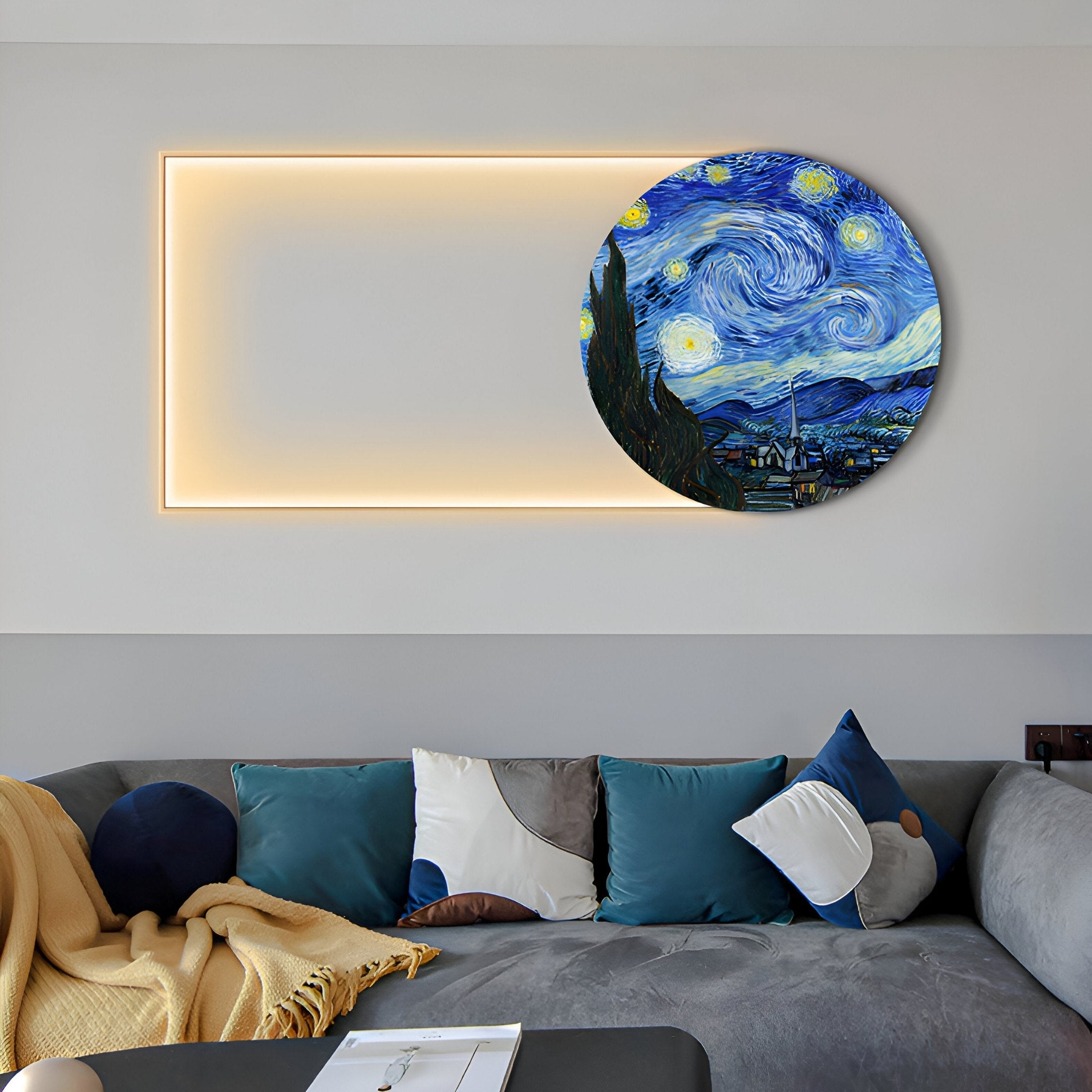 A cozy living room showcases Giant Sculptures Orion Starry Skies Oil Painting LED Wall Art, illuminating softly. Below it, a gray sofa adorned with blue, gray, white, and mustard yellow pillows and a matching blanket heightens the cosmic charm of the space.