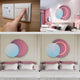 A person presses a light switch on a wooden wall. Two images show a modern bedroom with the Giant Sculptures’ Lunar Blush Sky Crystal Porcelain 3D White LED Wall Art above the bed, featuring overlapping pastel circles with LED illumination highlighting one circle.