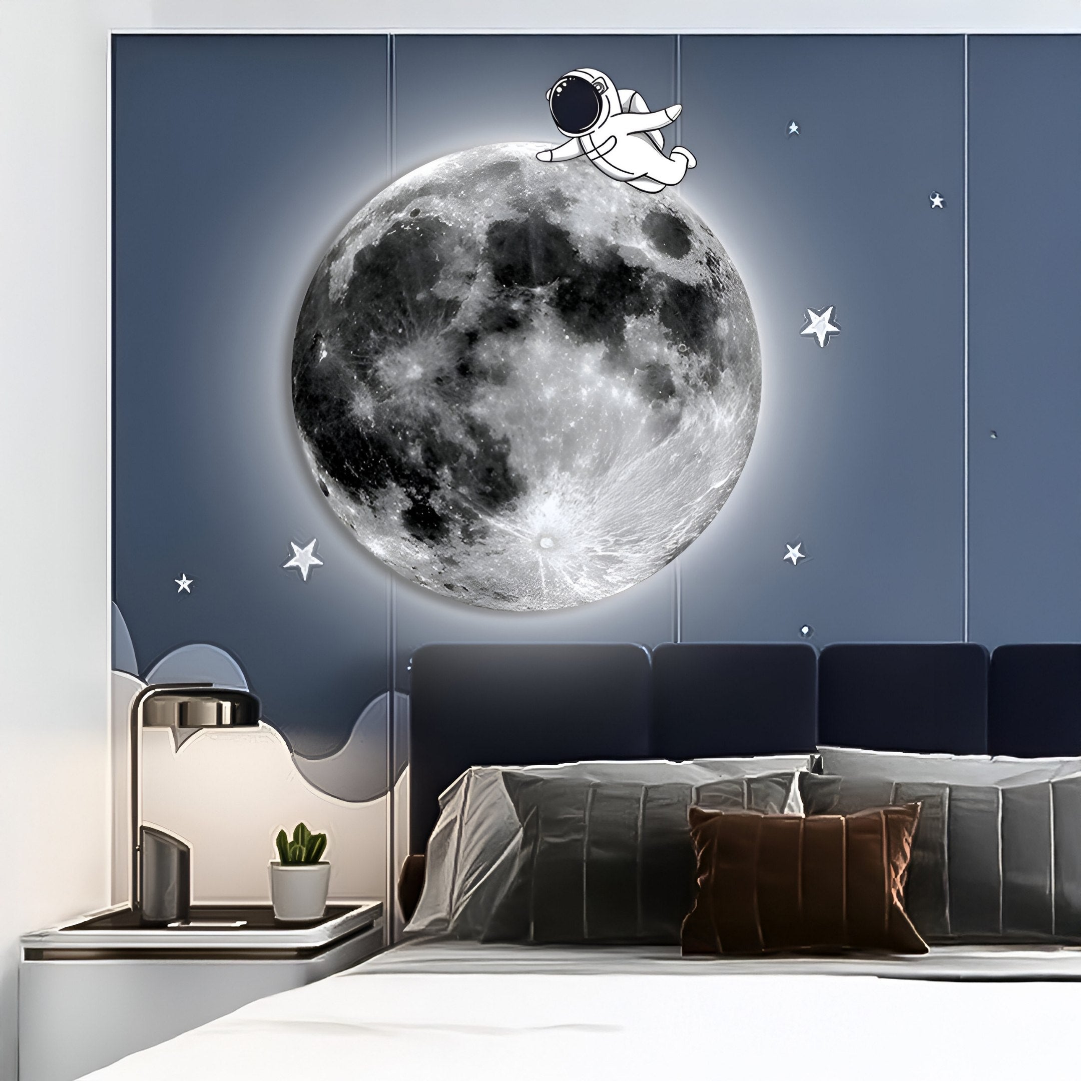 A bedroom features a Cosmos Astronaut Drift UV Wood Carving LED Wall Art by Giant Sculptures, showcasing a glowing moon and astronaut. The dark headboard complements a bedside table with modern lamp, small plant, and stars enhancing the space-themed design.