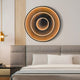 In a modern bedroom, the Reflex Gold Mirror 3D LED Wall Art by Giant Sculptures shines above the bed, displaying radiant concentric rings. The rooms elegance is enhanced by luxury wall decor, a neutral color palette, and a grey headboard next to the pendant light.