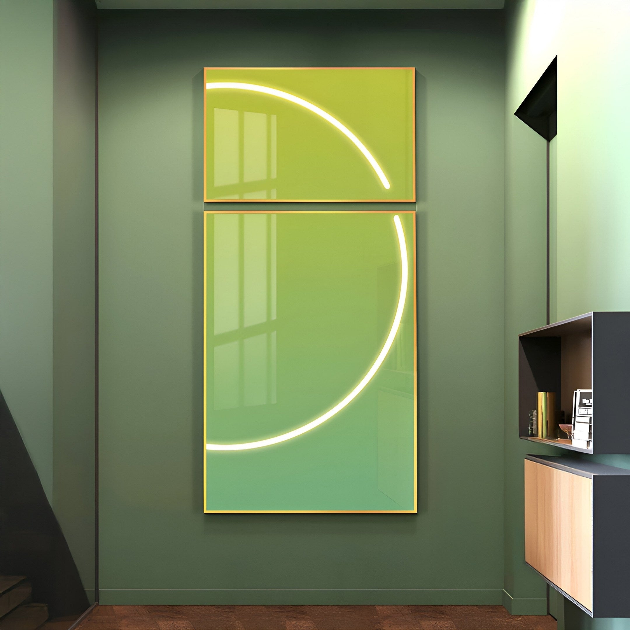 In a modern room, the Enigma Lime Jade LED Wall Art by Giant Sculptures features two abstract artworks with glowing arcs: a partial arc above and a larger arc below. A small counter with shelves on the right complements this striking display.