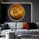 A modern living room features a gray sofa with orange and dark pillows. The wall glows warmly with the round Galaxia Venus Crystal Porcelain LED Wall Art from Giant Sculptures. In front, a small white table holds a handcrafted porcelain bird figurine, embodying modern design ideals.