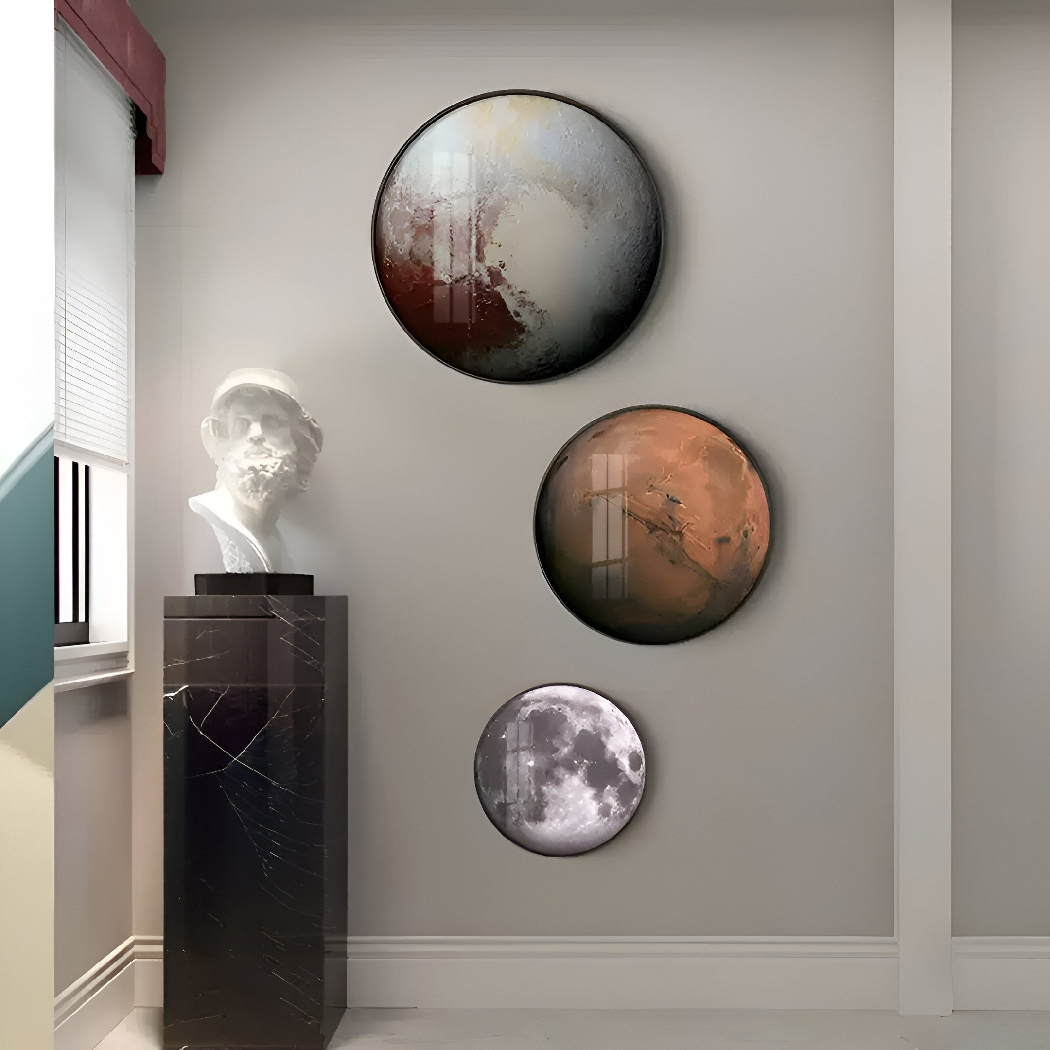 A minimalist room showcases three Galaxia Mars Crystal Porcelain LED Wall Art pieces by Giant Sculptures, evoking the allure of the Red Planet with celestial designs in red, dark, and white. A classical bust on a black marble pedestal complements the setting beside a window with blinds.