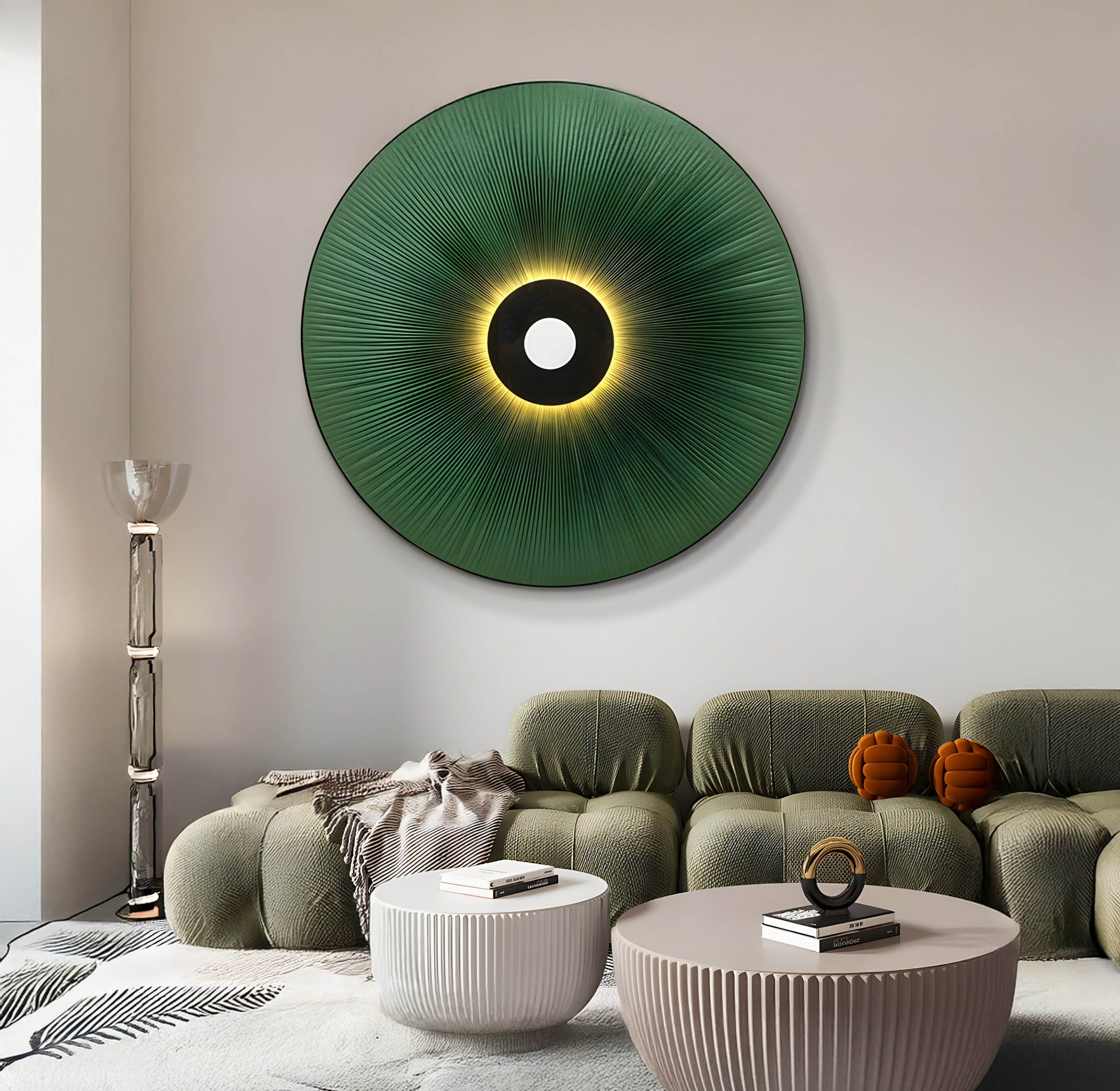 A modern living room features organic-inspired design with the Vanguard Jade Surge Leather 3D LED Wall Art by Giant Sculptures. An olive green sofa with cushions, a fringed throw, two pumpkin decor items, cylindrical glass lamps, and ribbed white coffee tables complete the look.