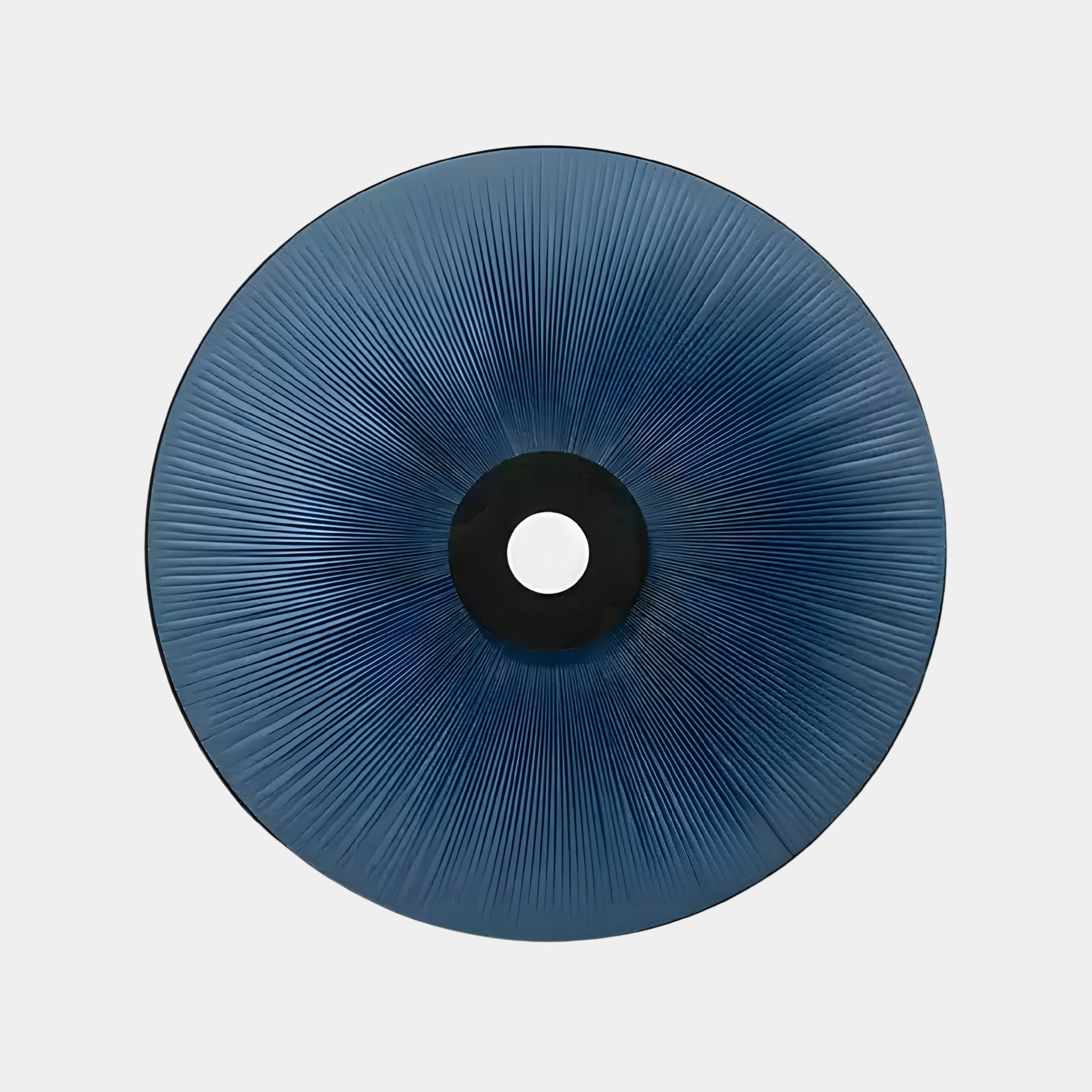 The Giant Sculptures Vanguard Midnight Indigo Leather 3D LED Wall Art features a blue with indigo-hued radial design emanating from a central black circle, resembling fine lines or pleats for a sunburst effect, and its simplicity stands out against the plain white background.