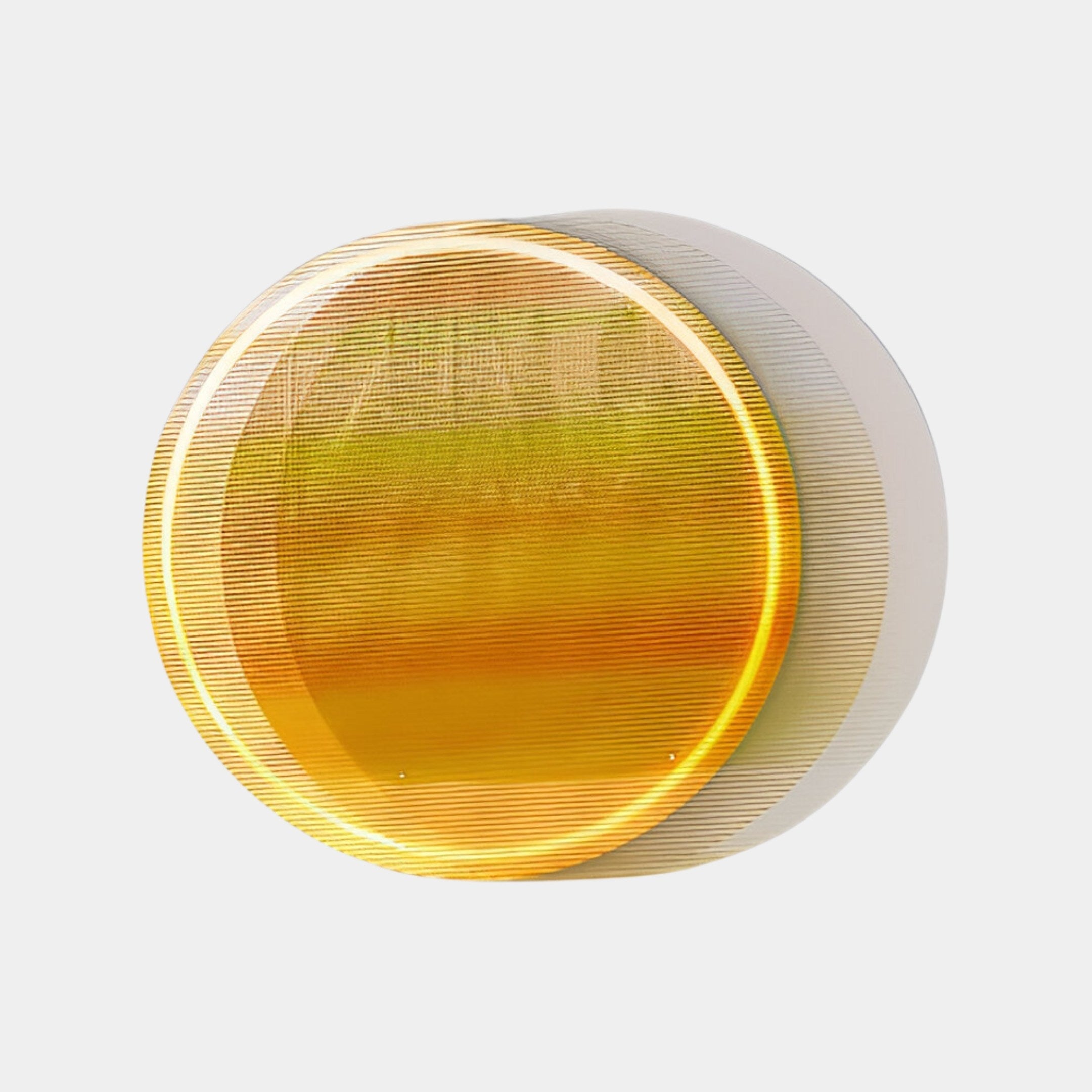 A round, amber-hued, translucent object with concentric layers resembles Chromia Golden Horizon by Giant Sculptures. It softly shadows a plain backdrop under ambient light, creating a gradient from amber to white.