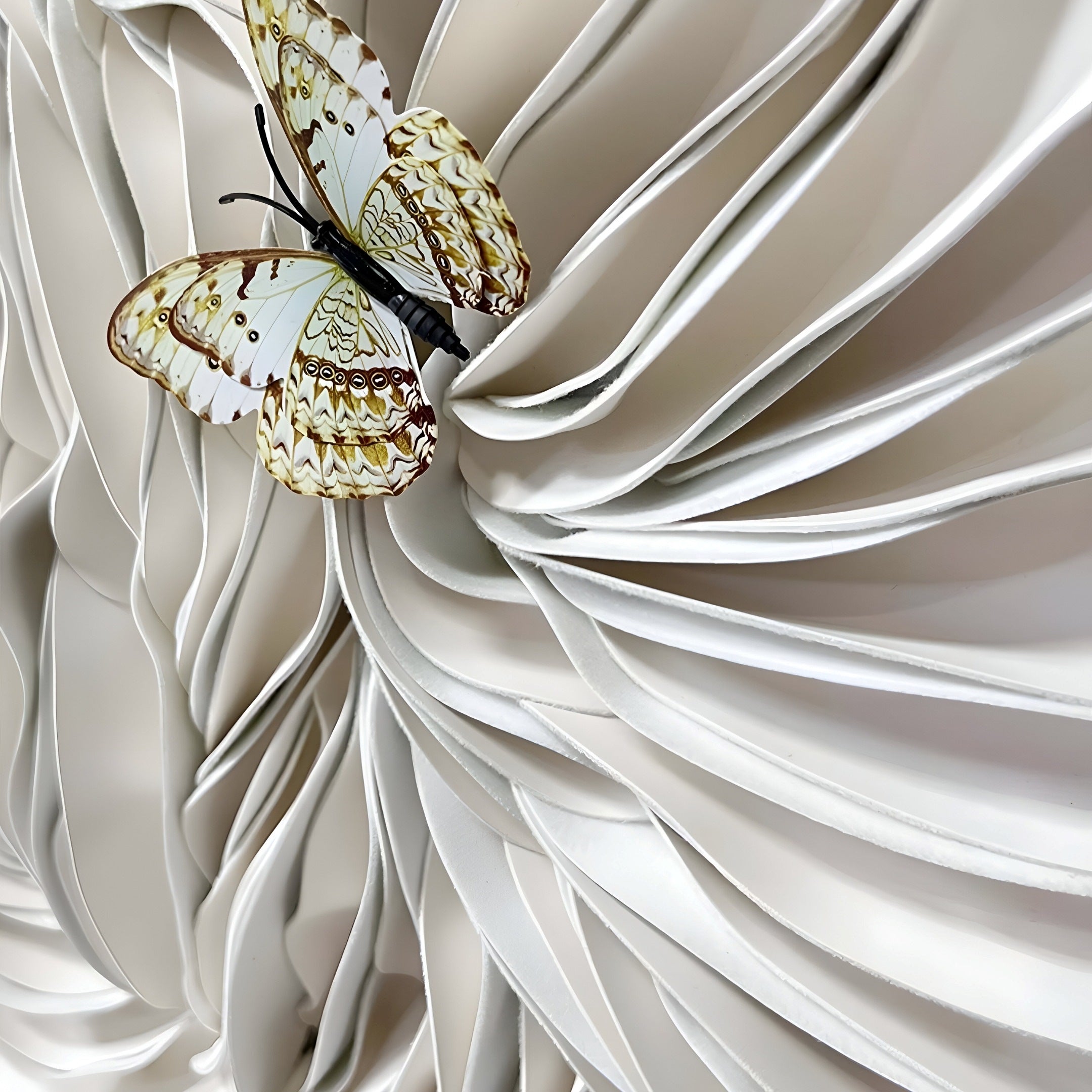 The Blossom Serenity White Leather 3D LED Wall Art by Giant Sculptures showcases a delicate butterfly with detailed wings on intricately folded white leather, creating a modern decorative piece that adds depth and contemporary appeal to any space.