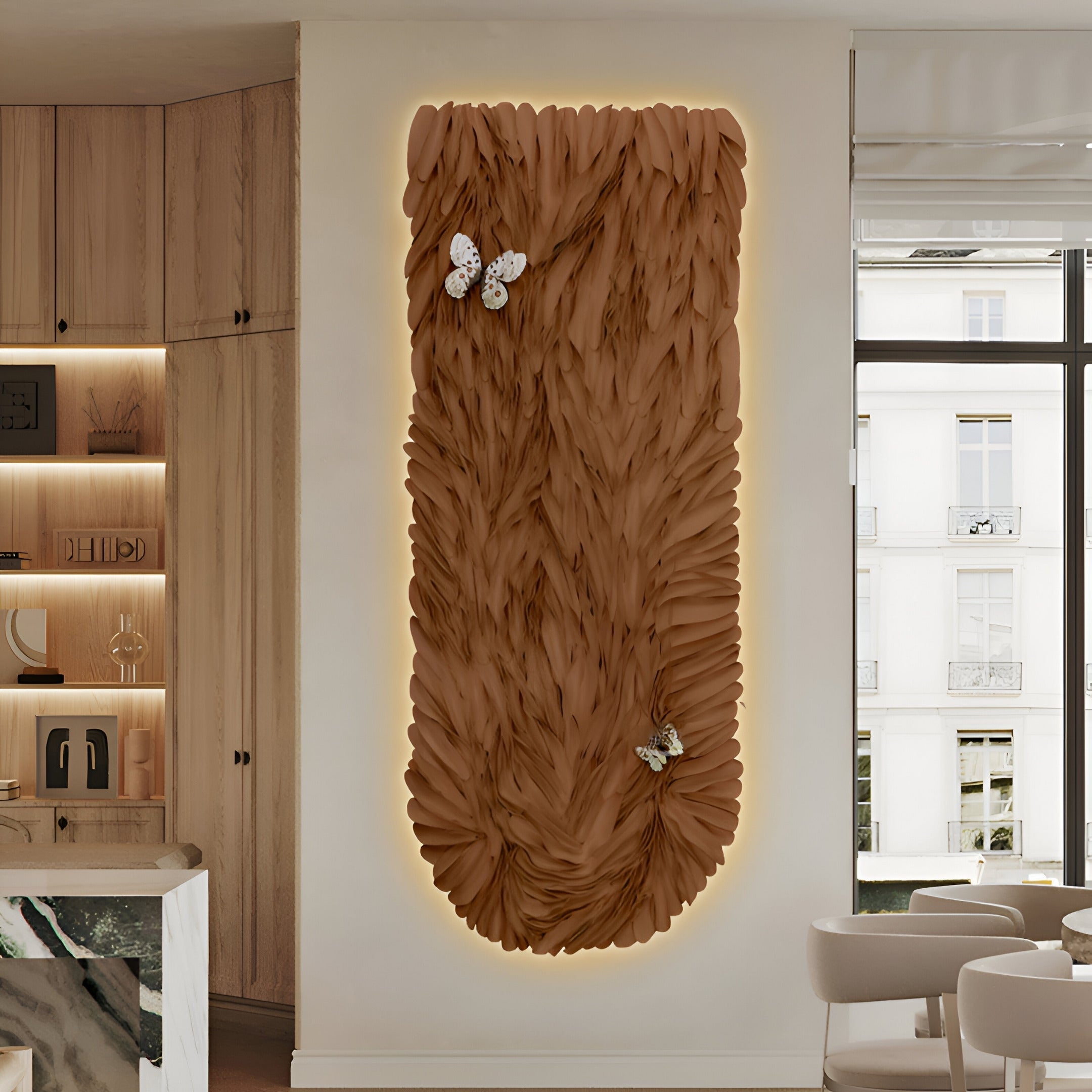 A modern interior features the Blossom Warm Terracotta Leather 3D LED Wall Art by Giant Sculptures, showcasing two white butterflies under soft lighting. Nearby, sleek wooden cabinets and books accentuate a window with a city view.