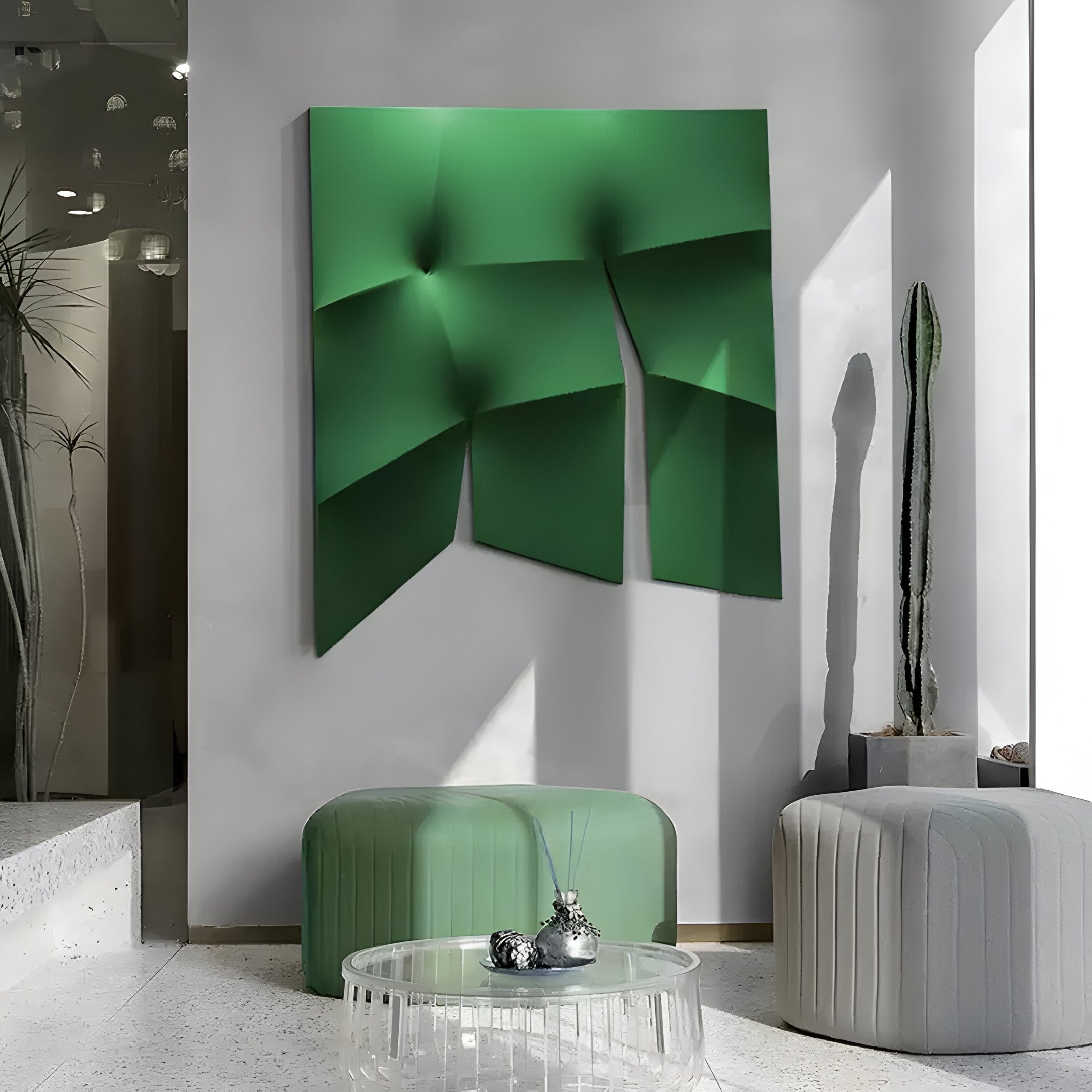 A chic contemporary interior boasts the Contours Emerald Green Elastic Fabric 3D Wooden Wall Art by Giant Sculptures. Two cylindrical ottomans, one green and another gray, complement a round glass coffee table. A tall cactus basks in sunlight through a window, completing this stylish ensemble.