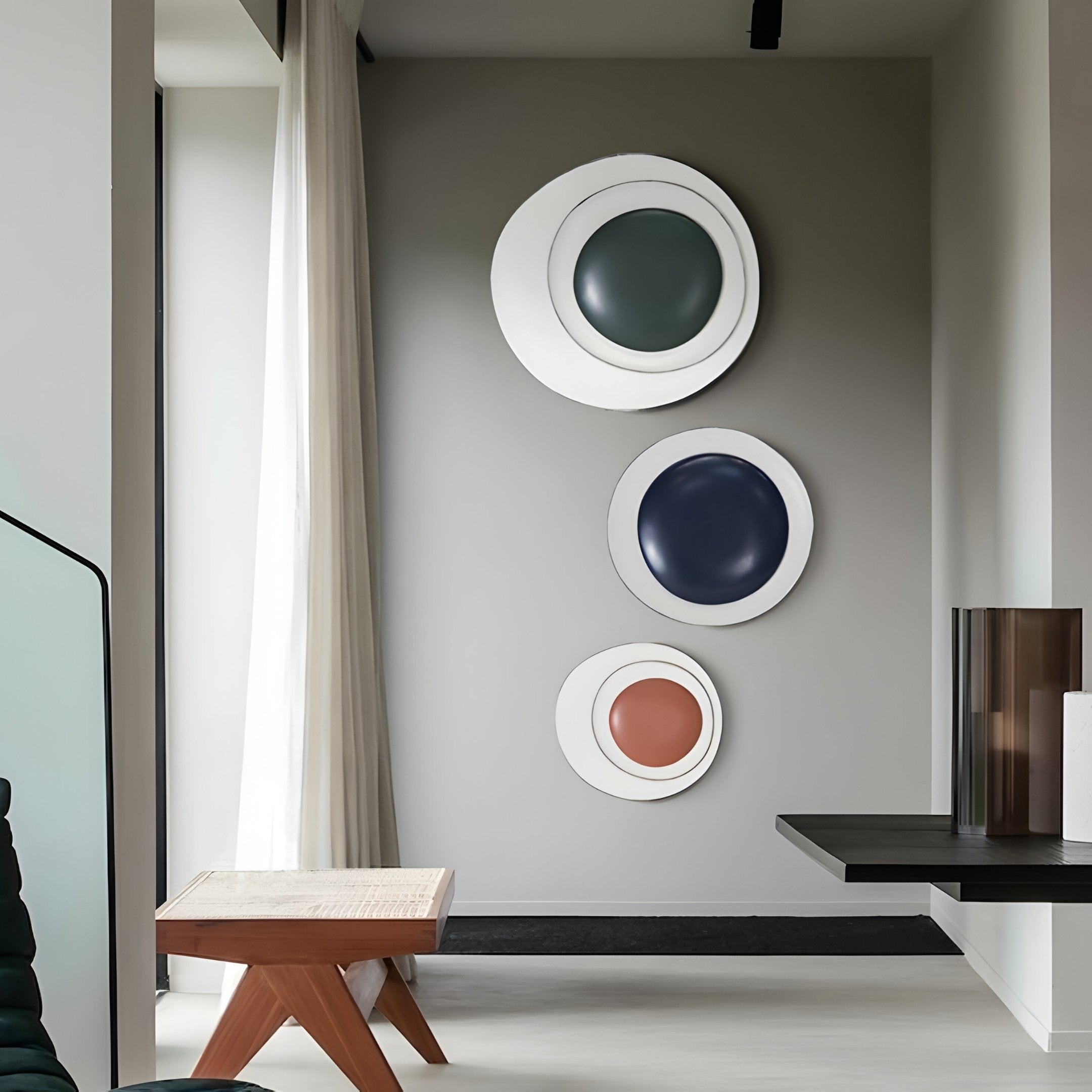 A modern interior features Giant Sculptures Aetherial Rosewood Glossy Circular Asymmetry 3D Wall Art in blue, green, and orange. Its complemented by a wooden stool, a black shelf with a glass vase, and sheer white curtains.