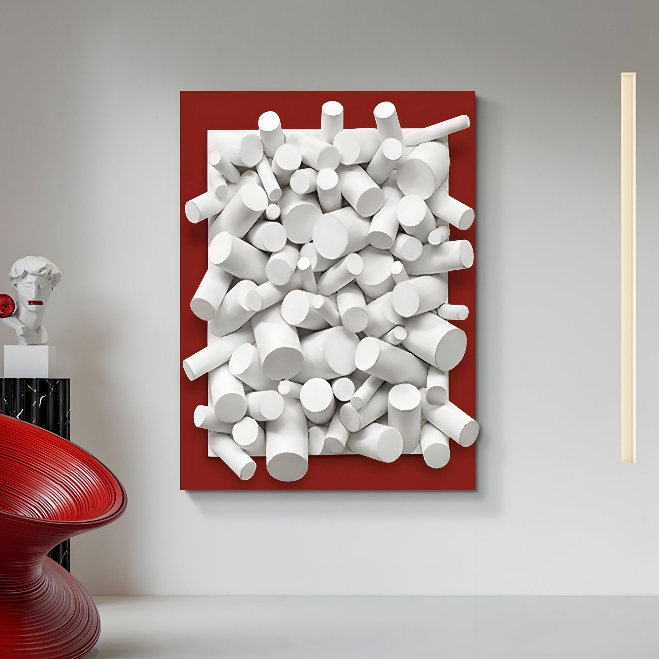 The Axion White Wood Cluster & Ruby Red Edge 3D Wall Art by Giant Sculptures features white cylindrical shapes on a ruby red background. Perfect for contemporary spaces, it pairs well with a neutral wall, a red spiral chair, and a small sculpture.