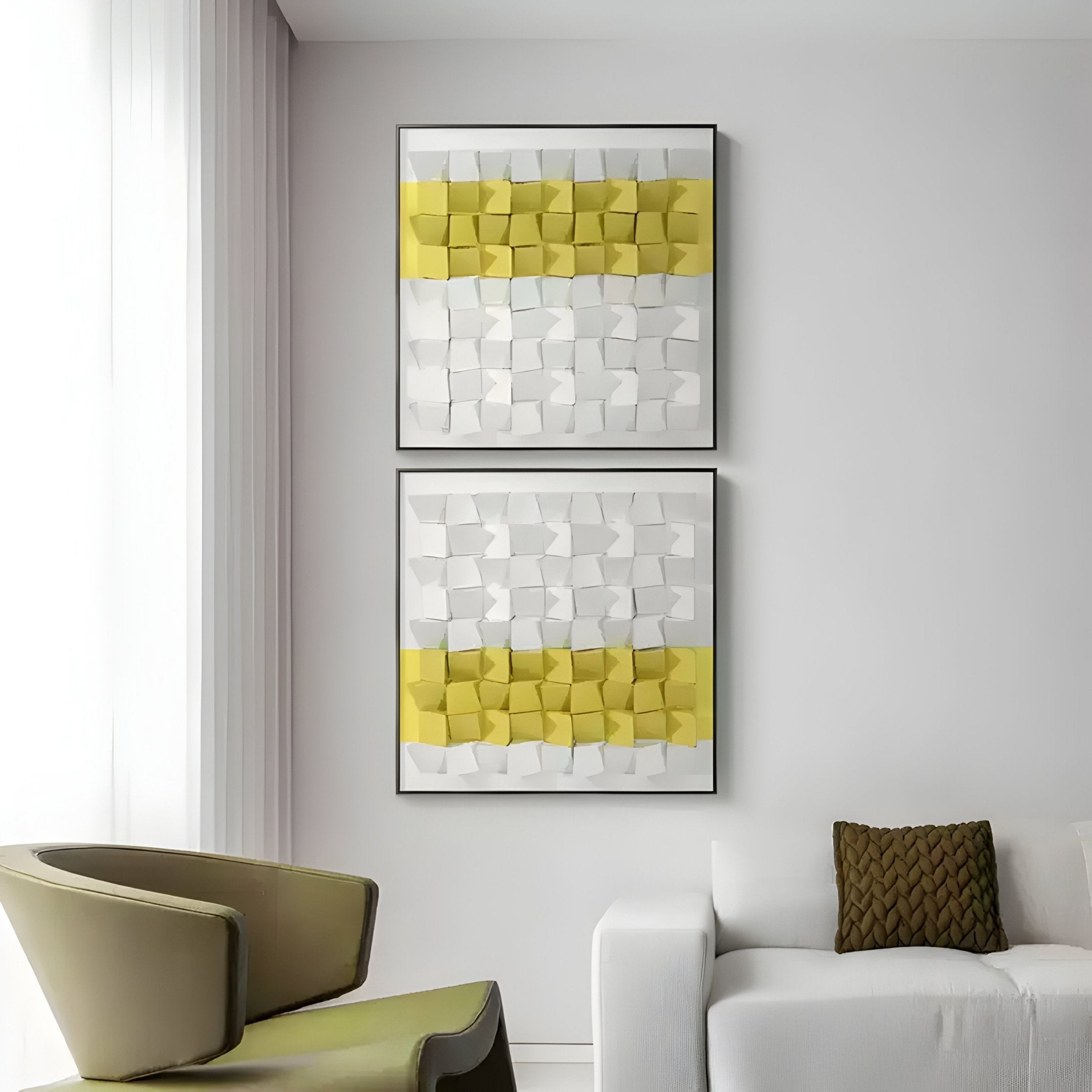 A modern living room features two Tessera White & Yellow II Geometric Wood 3D Wall Art pieces by Giant Sculptures, adding striking geometric patterns. A light-colored sofa with a brown cushion and a unique chair are in the foreground, while white curtains cover large windows.